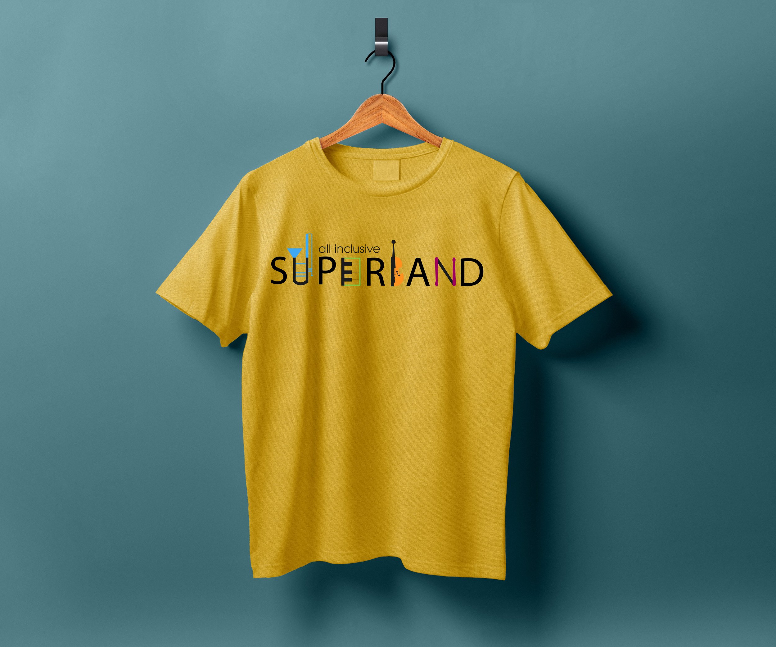 Gelbes T-Shirt mit buntem Schriftzug 'All Inclusive Superband' und grafischen Elementen, hängt an einem Holzkleiderbügel vor einer blauen Wand.