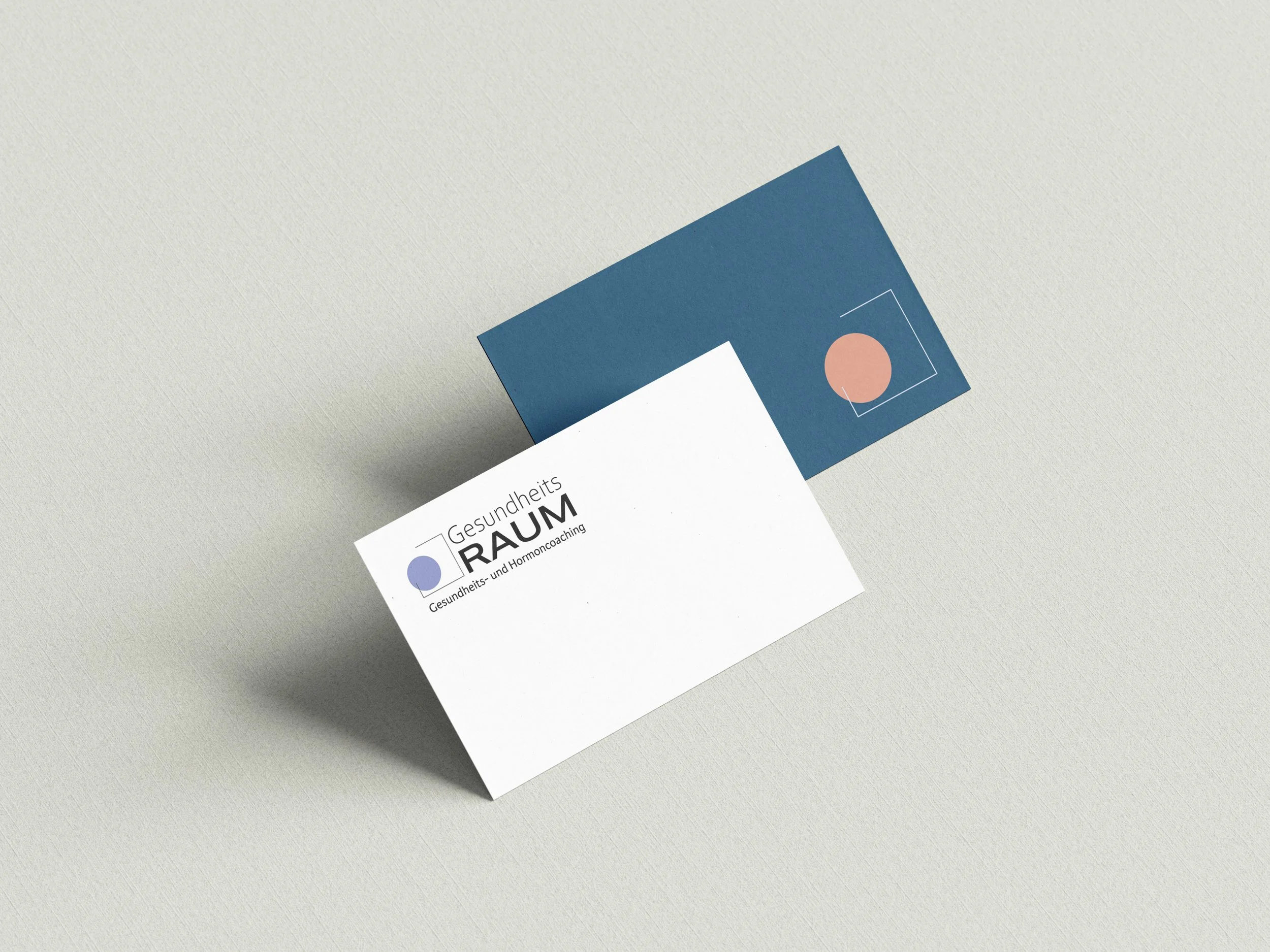 Zwei Visitenkarten für die Praxis Gesundheitsraum mit Logo und Text in Deutsch.