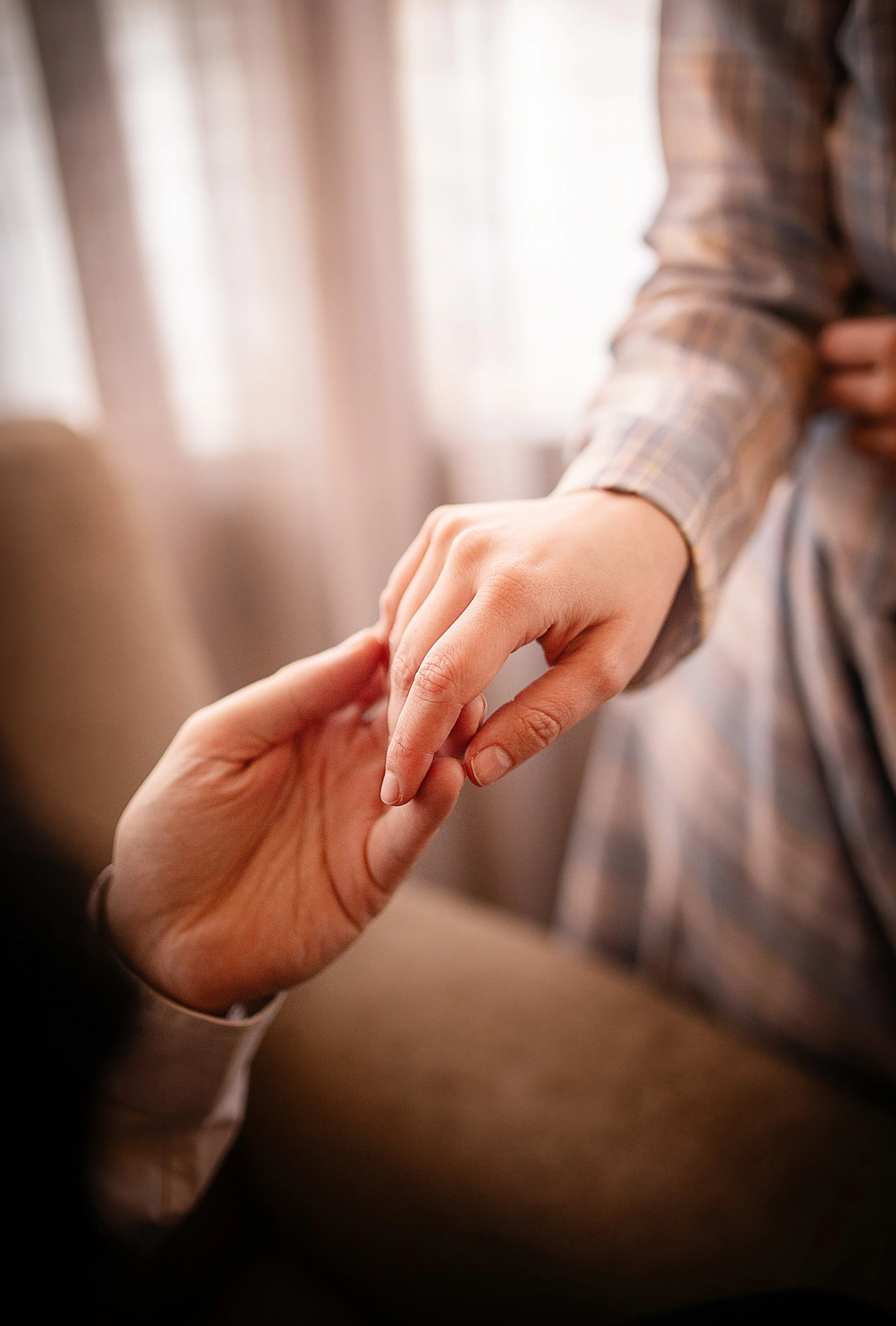 Una mano extendida tocando suavemente la mano de otra persona, en un ambiente cálido y difuso | ReVolution | Rol en Vivo España