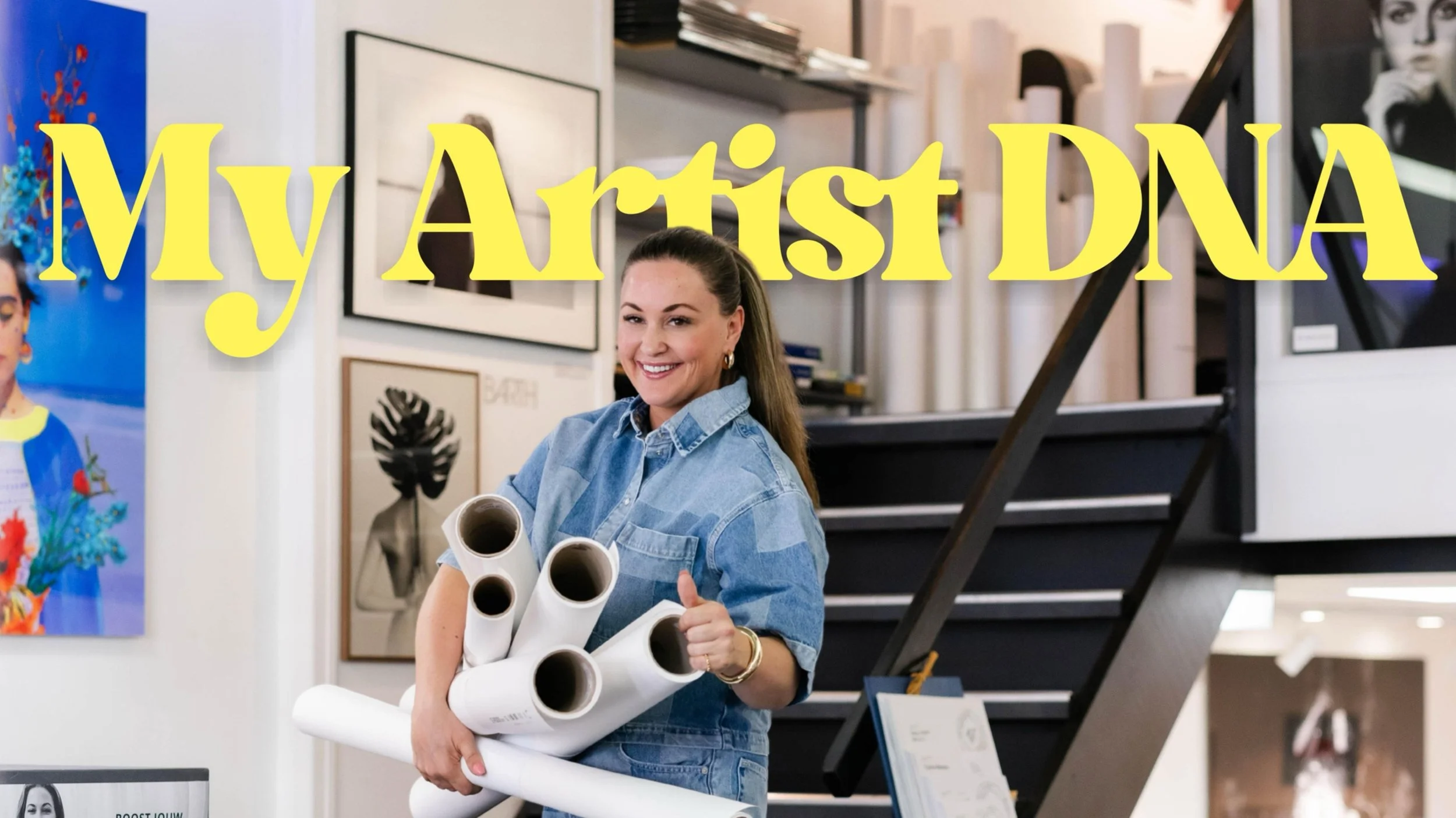 Vrouw in kunstgalerij of kunstwinkel die meerdere grote tekeningen of plannen vasthoudt.