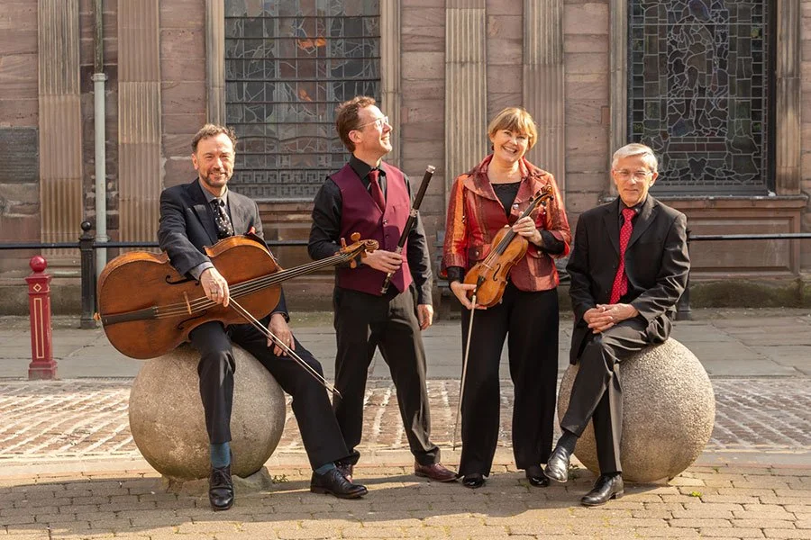 4 musicians outside a church