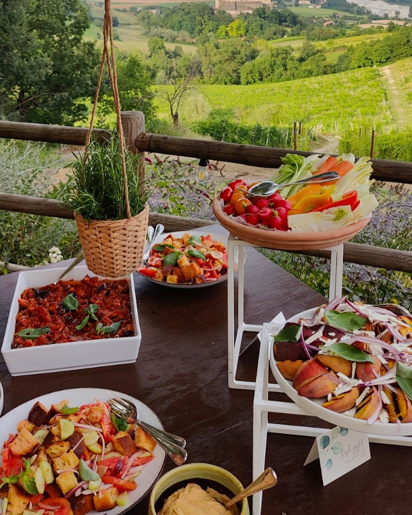 Tavolo all'aperto con piatti di verdure e pane tostato in campagna
