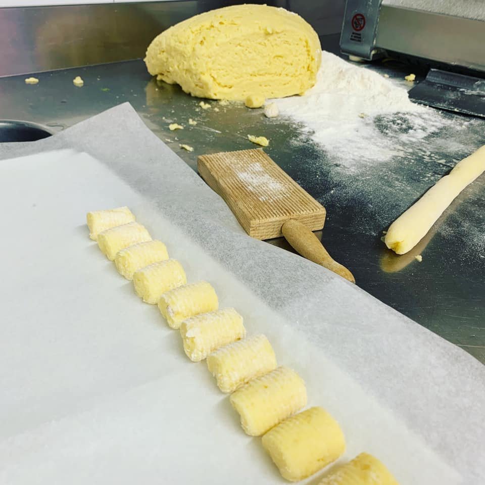 Preparazione di gnocchi su un piano da cucina con impasto e farina.