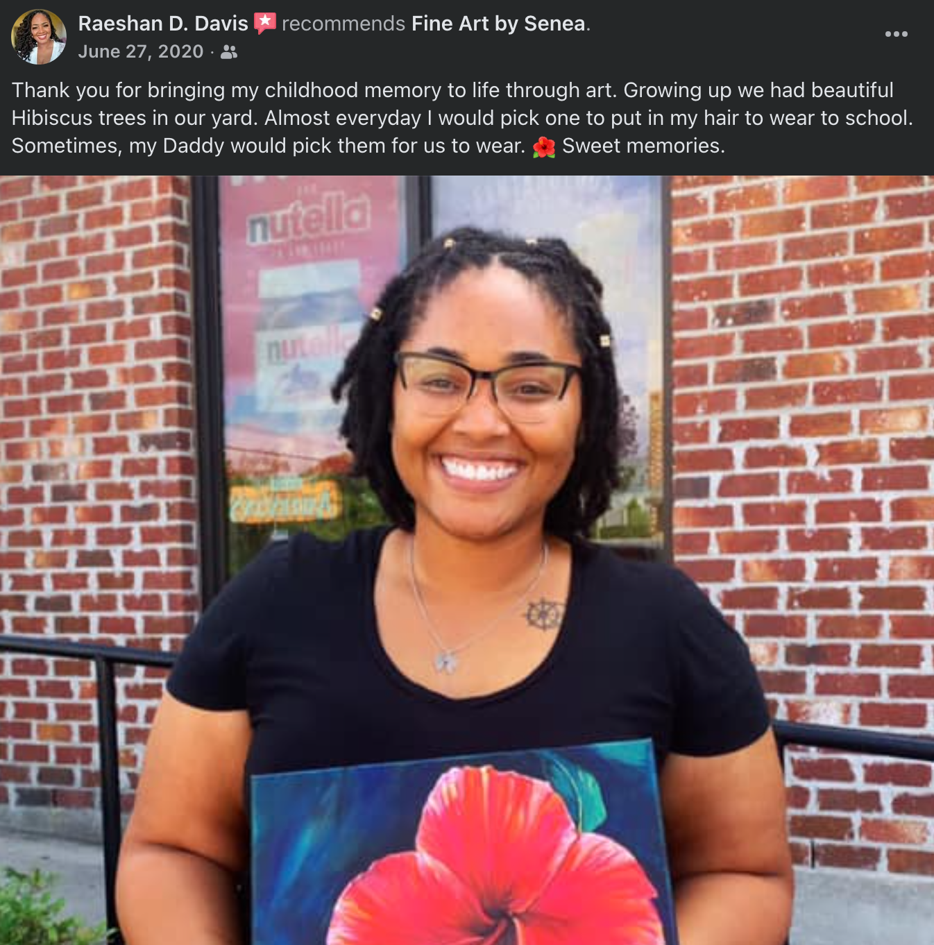Woman holding a painting of a hibiscus flower