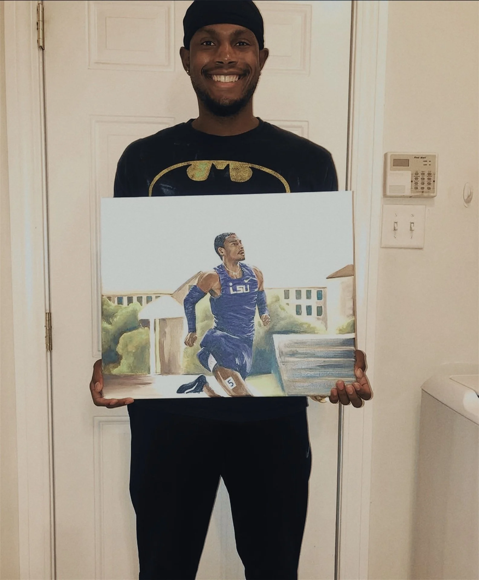 Man holding his sports painting portrait of track field scene