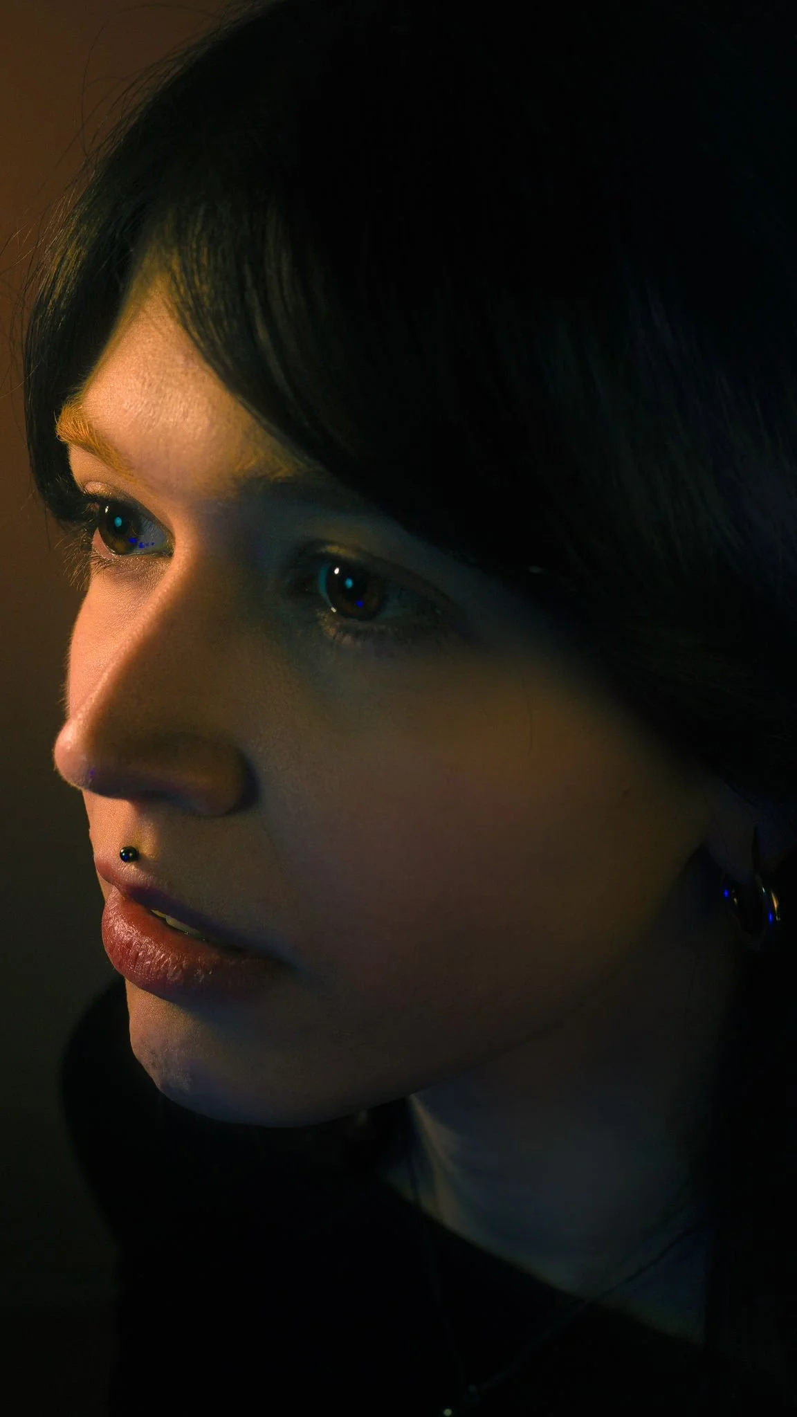 close-up portrait of Nausicaa looking to the side in dim warm light. photo credits: Roman Ermolaev