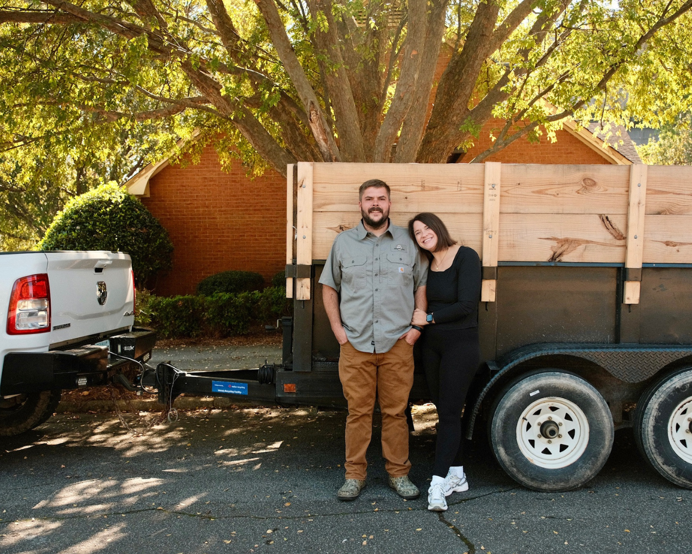 A man and a young child sitting on a forklift inside an industrial workshop.