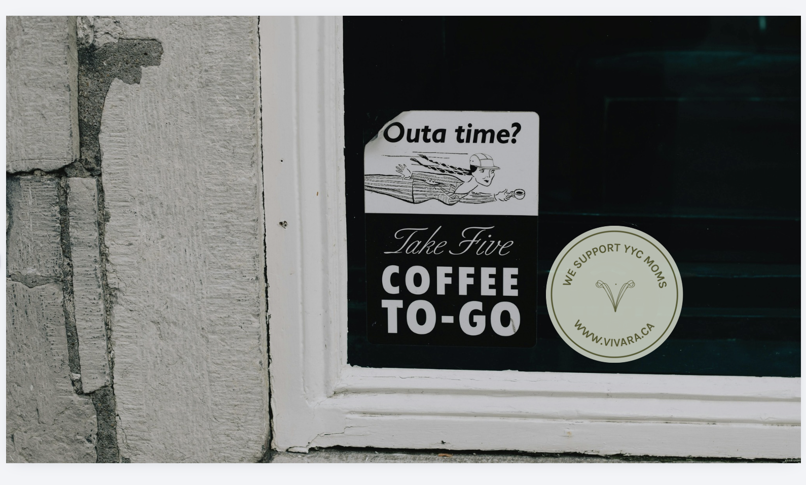 Woman breastfeeding a newborn while a nurse assists her, with a young girl watching nearby in a living room with a Christmas tree.