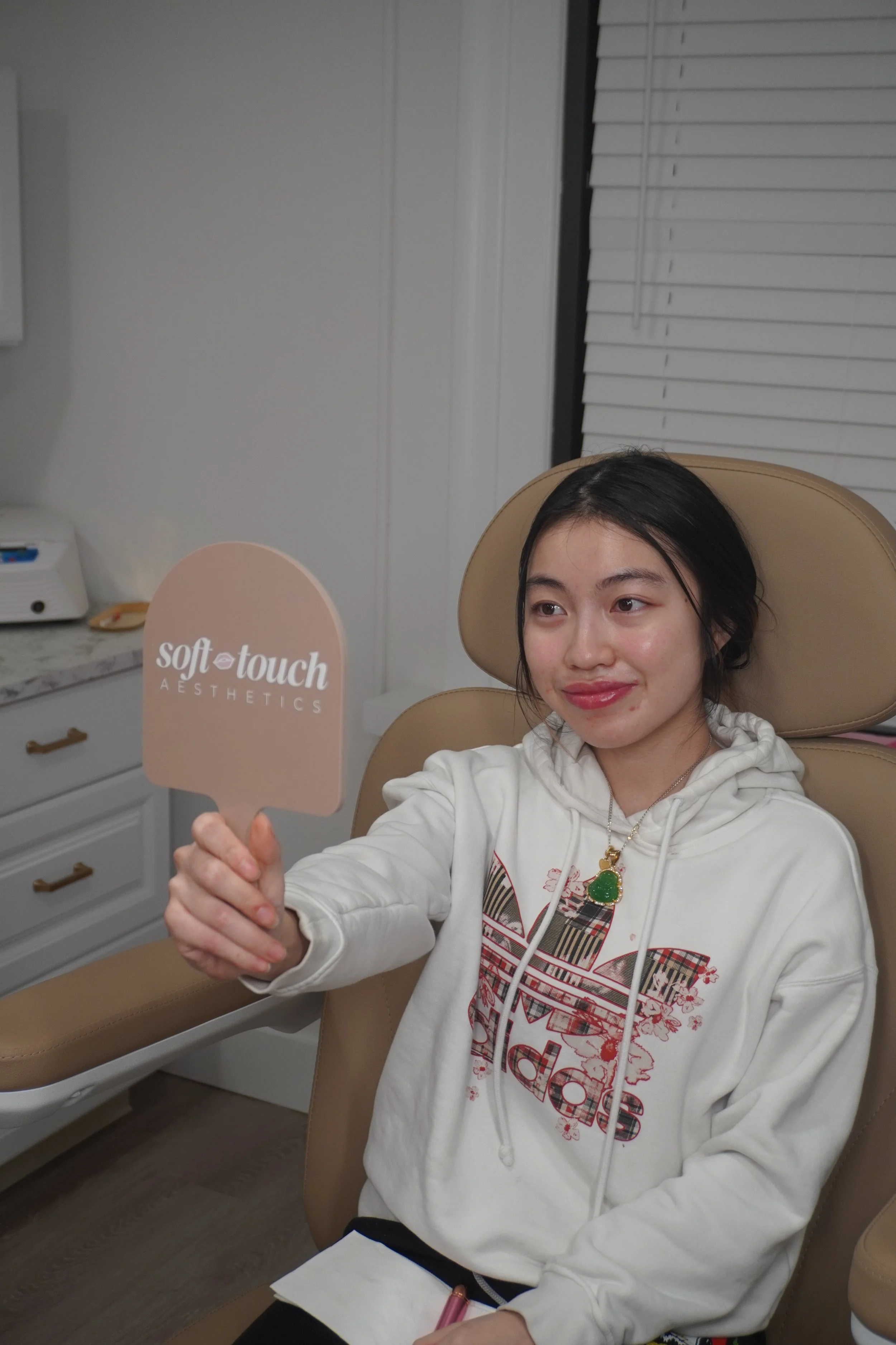 Client viewing her enhanced lips after natural lip filler treatment at Soft Touch Aesthetics med spa.