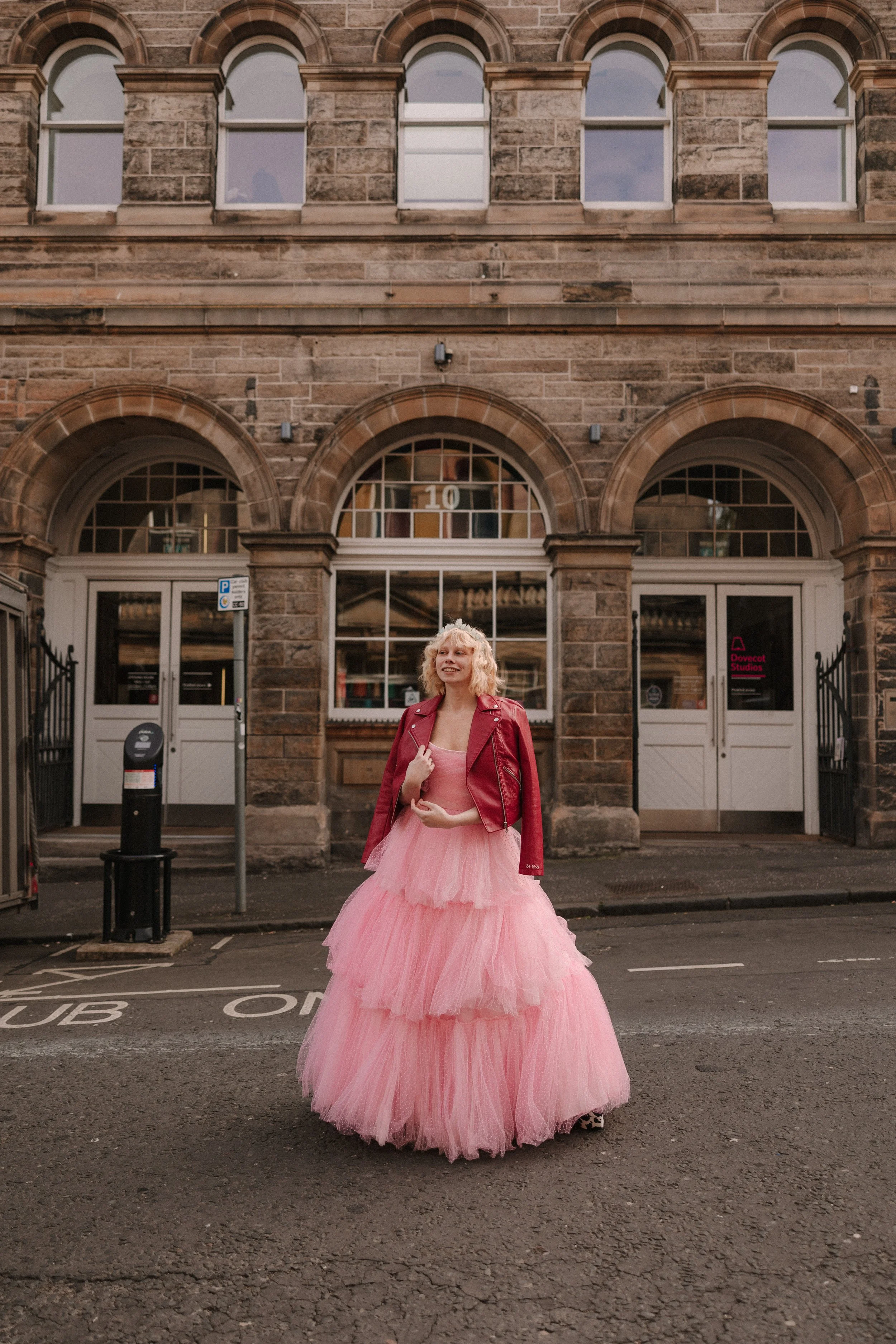 Edinburgh bride with pink dress and red leather jacket outside the Dovecot Studios