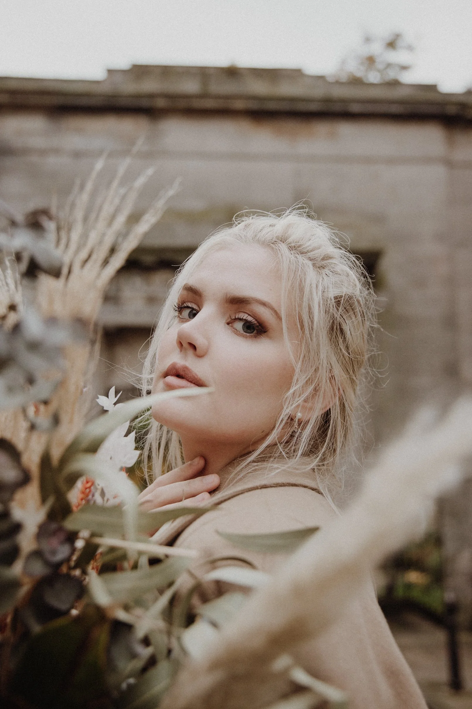  photo portrait of blonde model walking in edinburgh new town Stockbridge with a light camel coat and a bouquet of dried flowers in arm 
