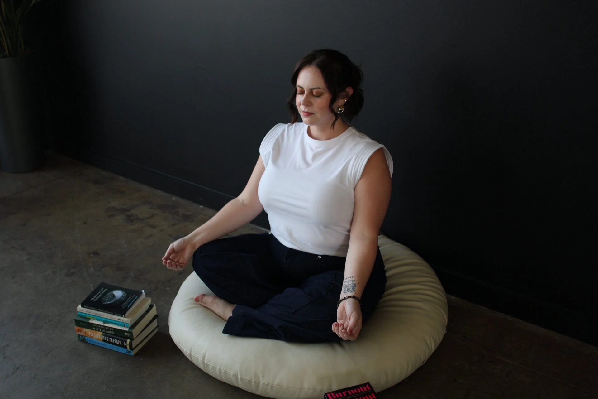 Therapist Aubrey Richardson sitting cross legged in a calm space practicing mindfulness, representing burnout recovery and therapy for therapists in Texas
