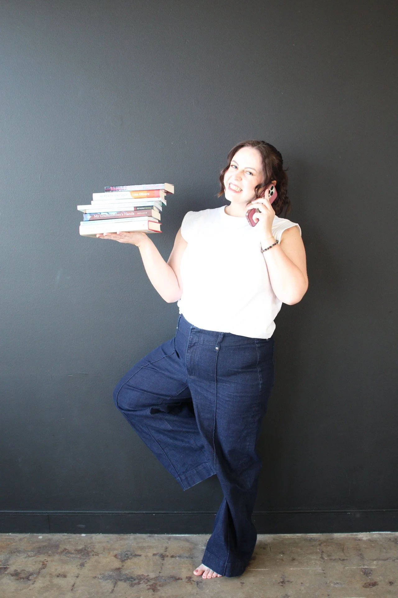 Aubrey Richardson, Texas therapist specializing in therapy for therapists and helping professionals, holding therapy books and a laptop to represent burnout recovery and support for high achieving clinicians