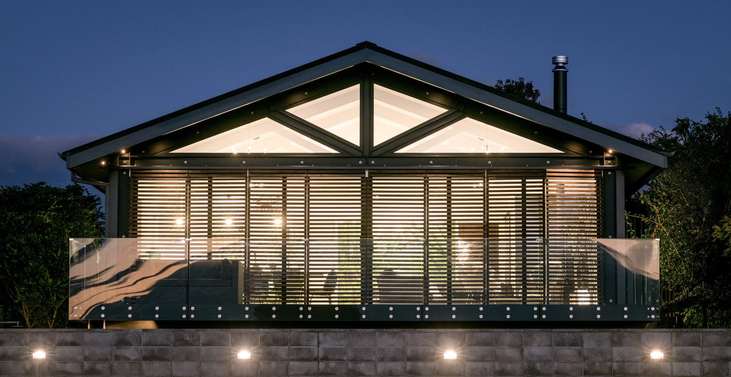 Nighttime view of gable end with stackers angled open to reveal lighting design
