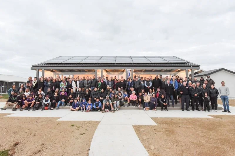 The whole Whanau and team in front of the communal building designed by Architectural Designer Keni-Duke Hetet