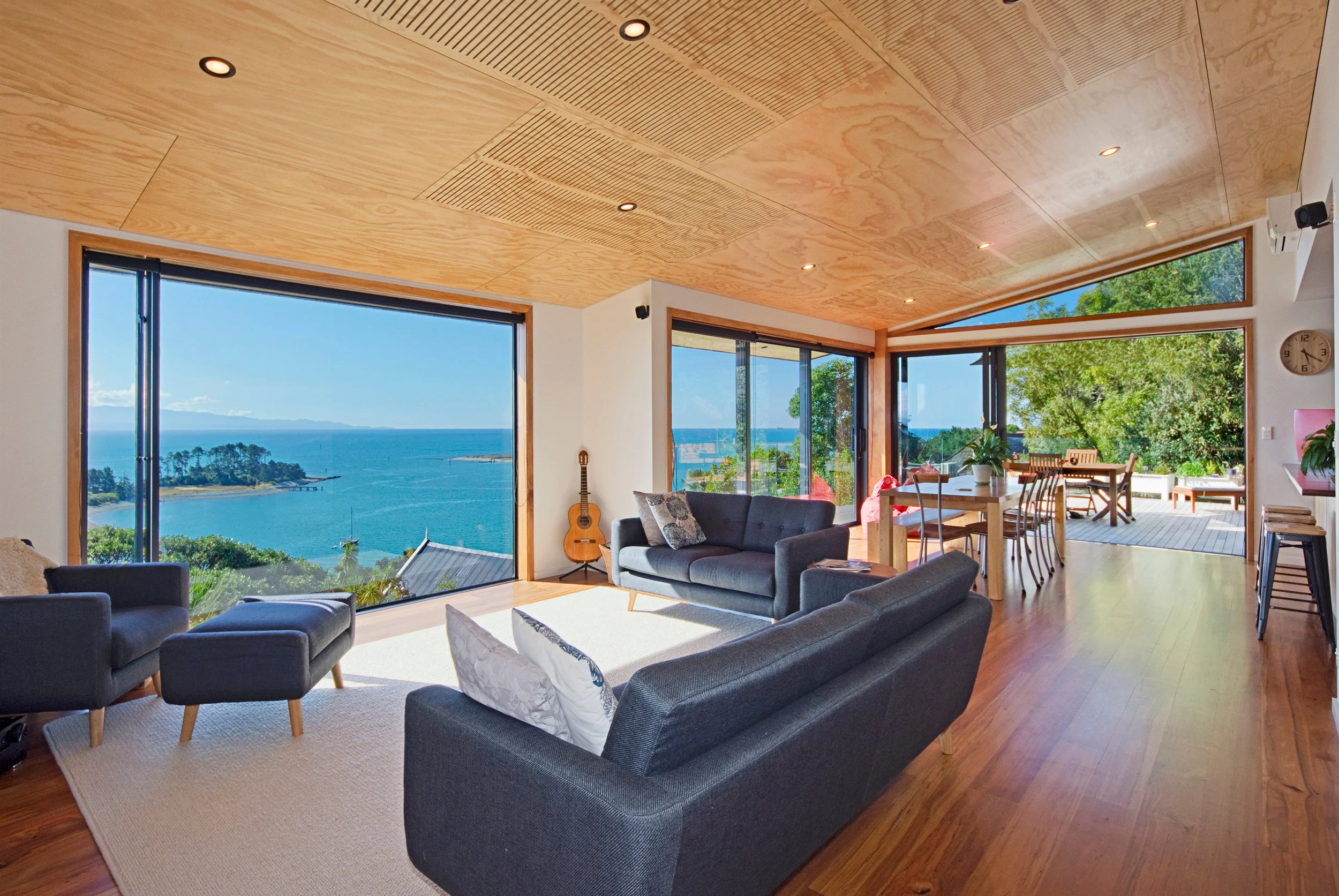 Extensive alteration with recycled rimu floor and plywood panels for ceiling as well as large windows and sliders to frame views, designed by architectural designer Keni-Duke Hetet