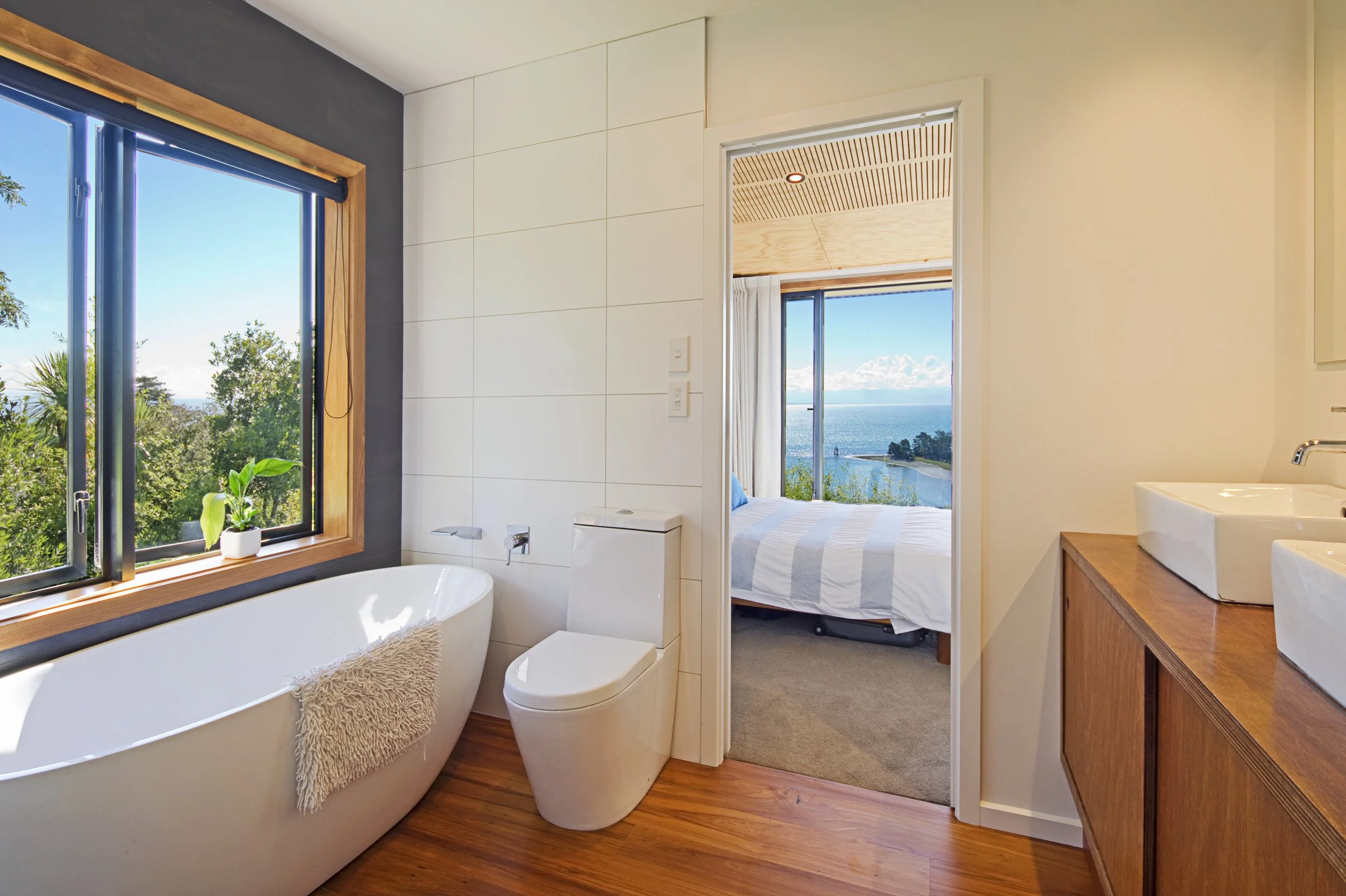 Ensuite bath tub and view though master bedroom to the water and island