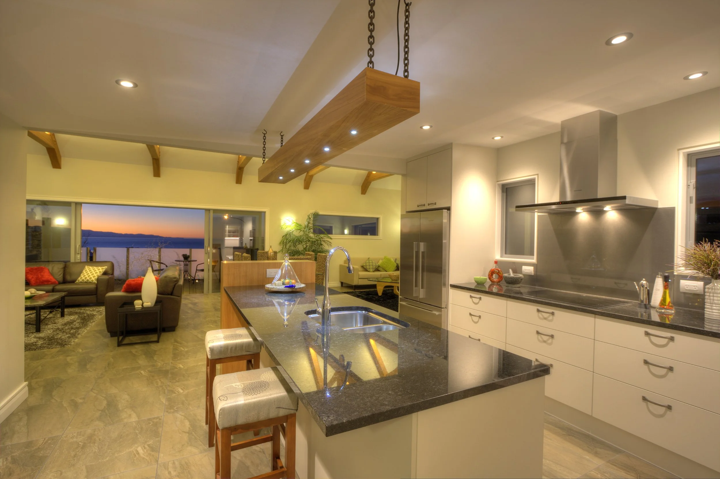 Dusk sunset view out western side new home toward Western Ranges Nelson, large stacker doors open out to take in expansive views