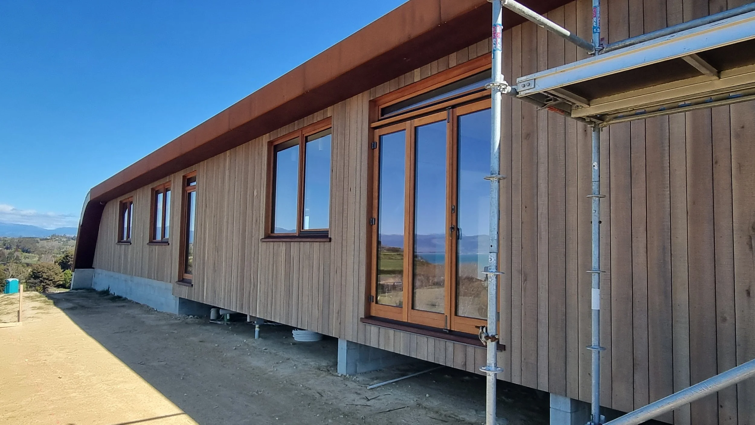 Facade of Tasman home under construction with timber cladding and Corten detail by Keni-Duke Hetet architectural designer Nelson 