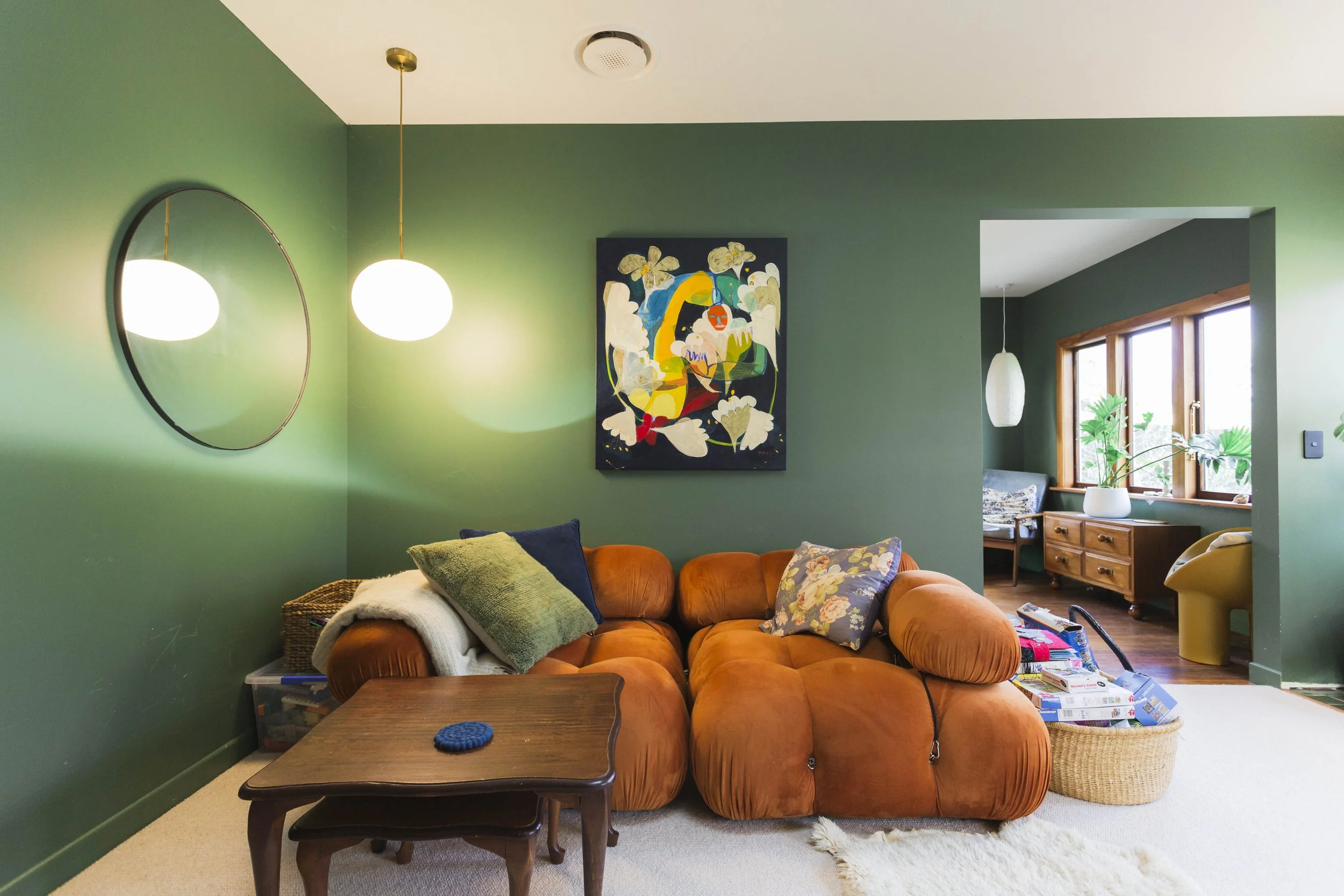 Snug area, large orange couches and mossy green walls