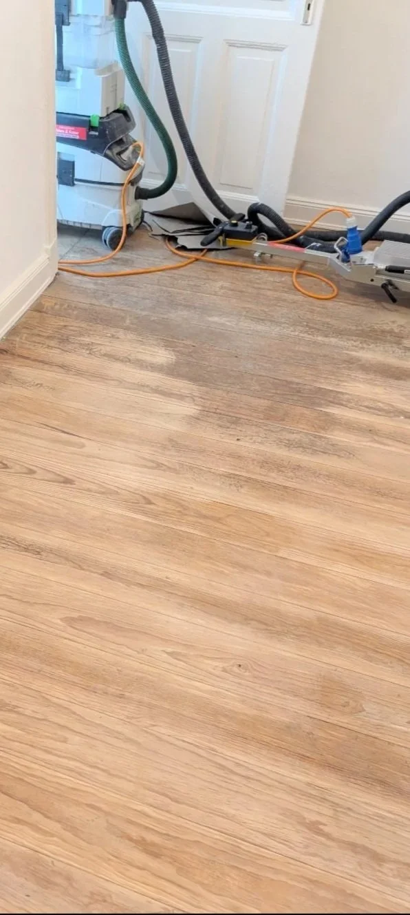 Boden wird frisch abgeschliffen, mit Schleifmaschine und Staubsauger im Einsatz.