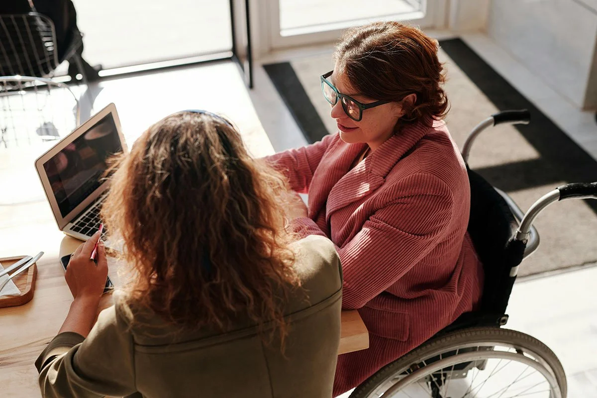 nonprofit leader working with nonprofit consultant casually at table with laptop