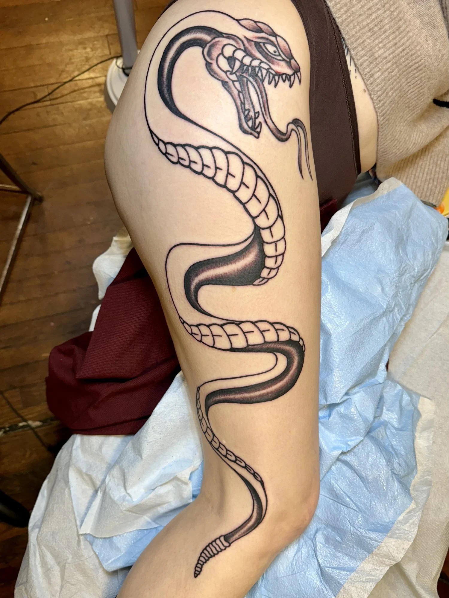 Solid black cobra tattoo running down a thigh.jpg