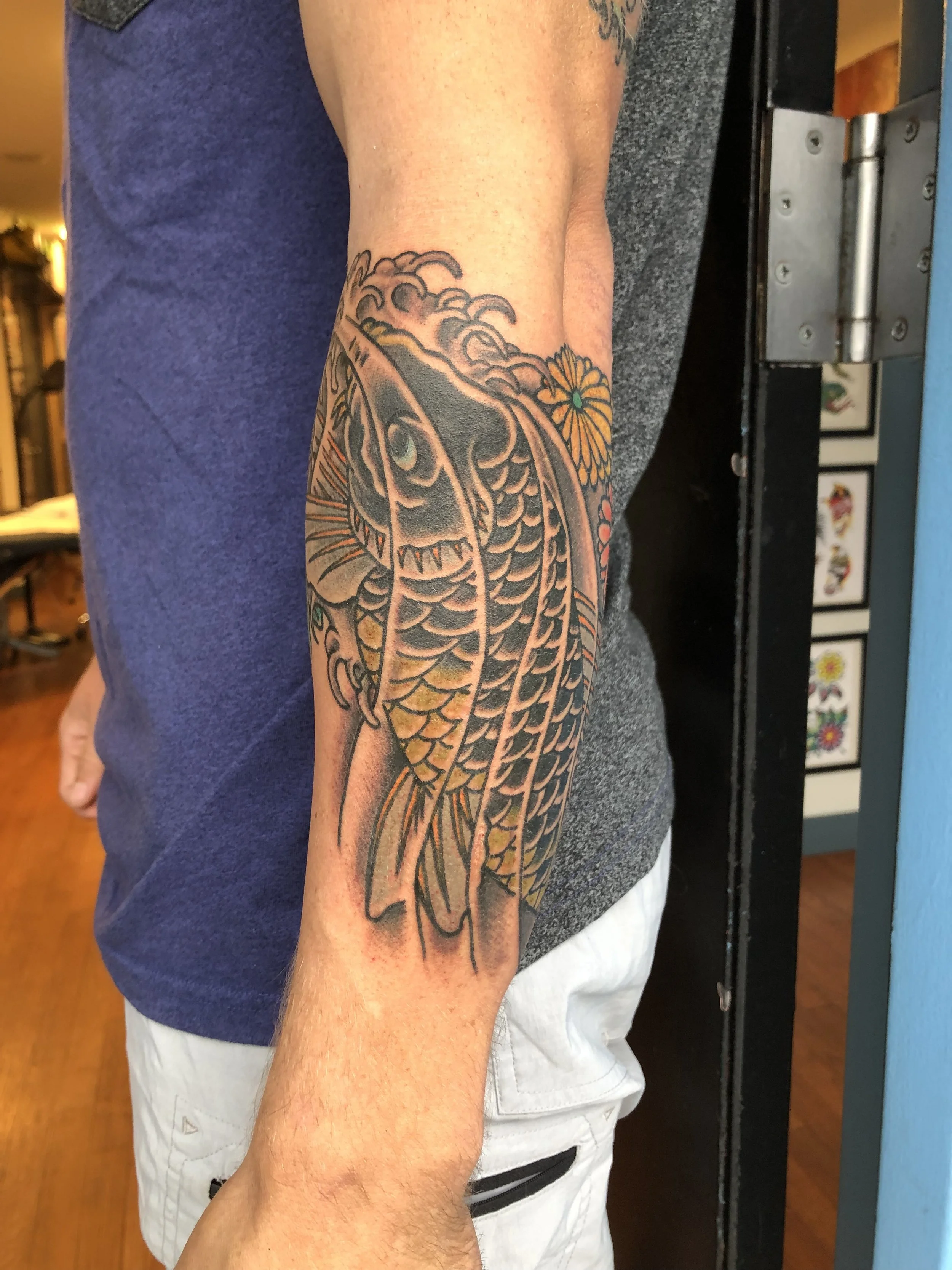 Black and grey Japanese koi fish tattoo with waves and cherry blossoms by Electric Lotus Tattoo in NYC
