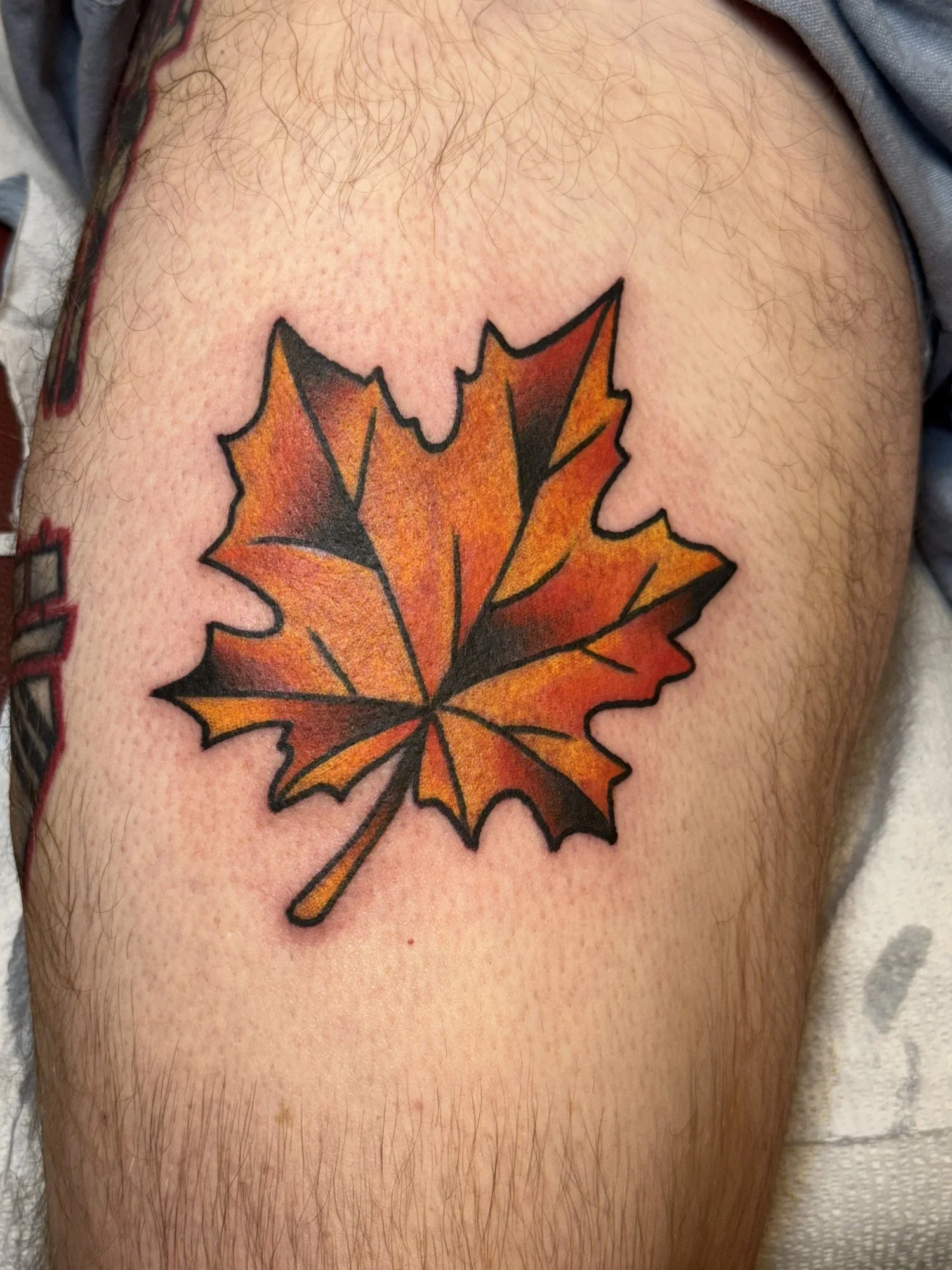 Autumn maple leaf tattoo on a thigh.jpg