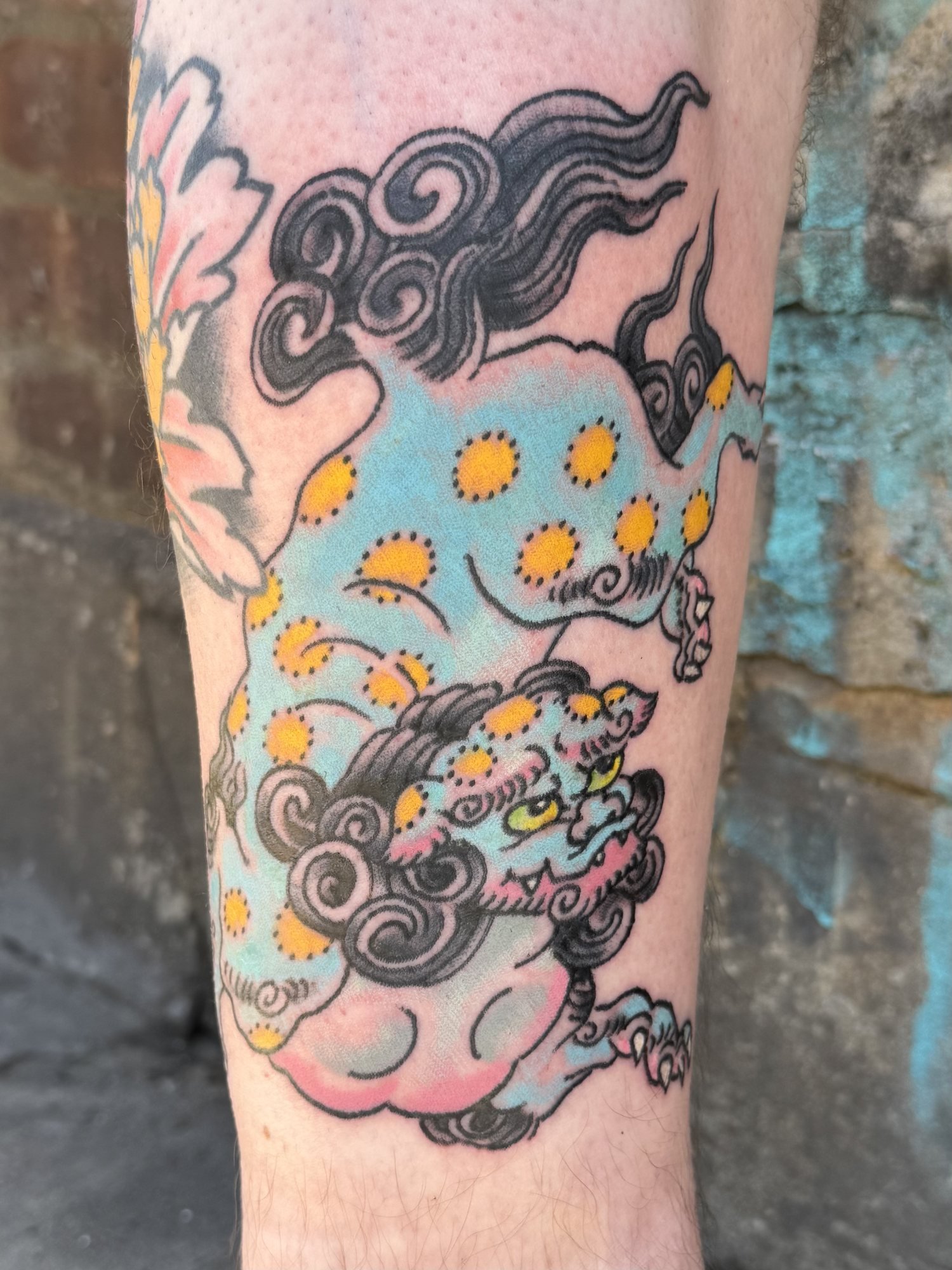 Japanese foo dog and clouds tattoo on an arm by Jae Connor.jpg