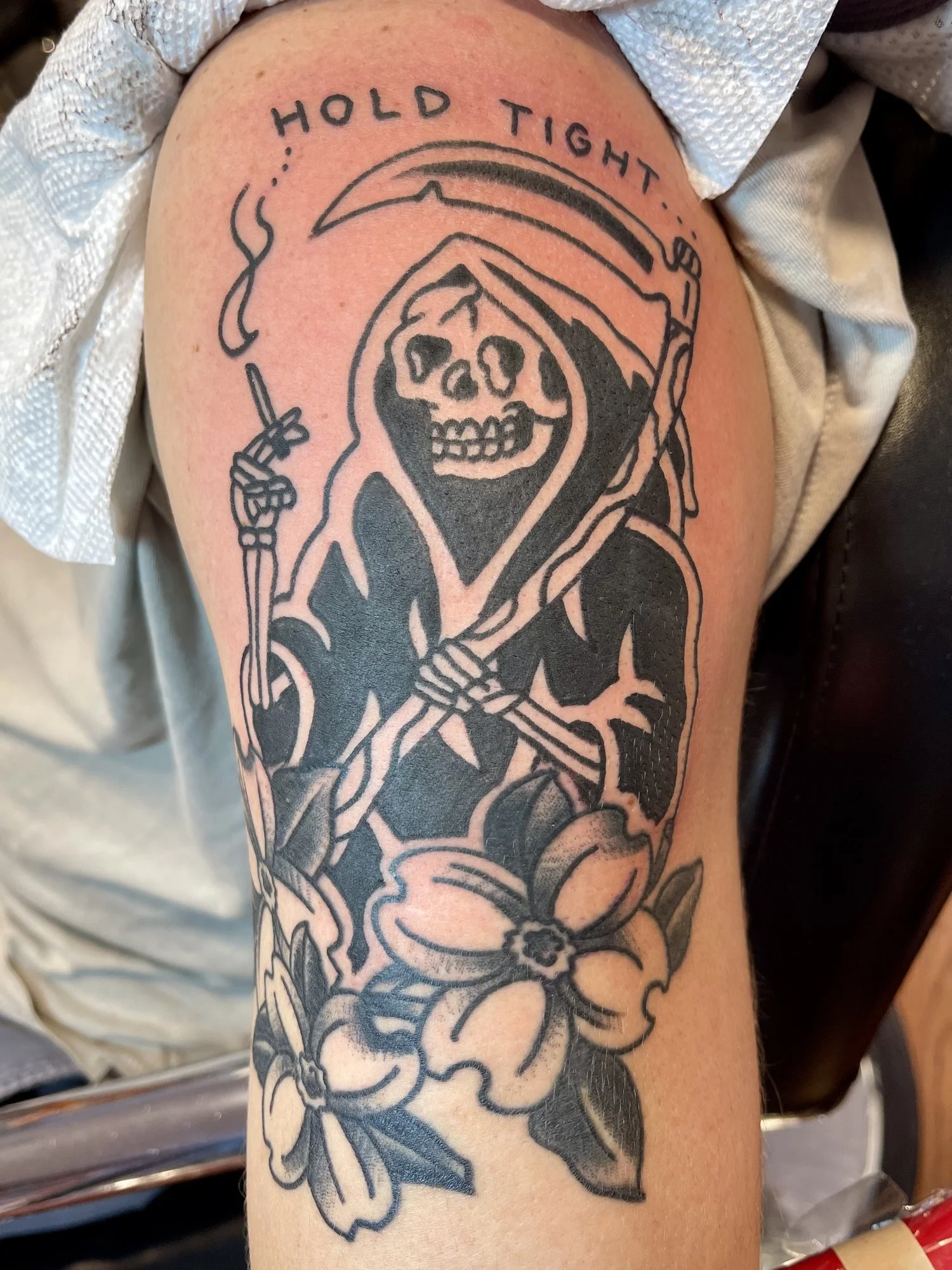 Blackwork reaper and flowers tattoo on a thigh.jpg