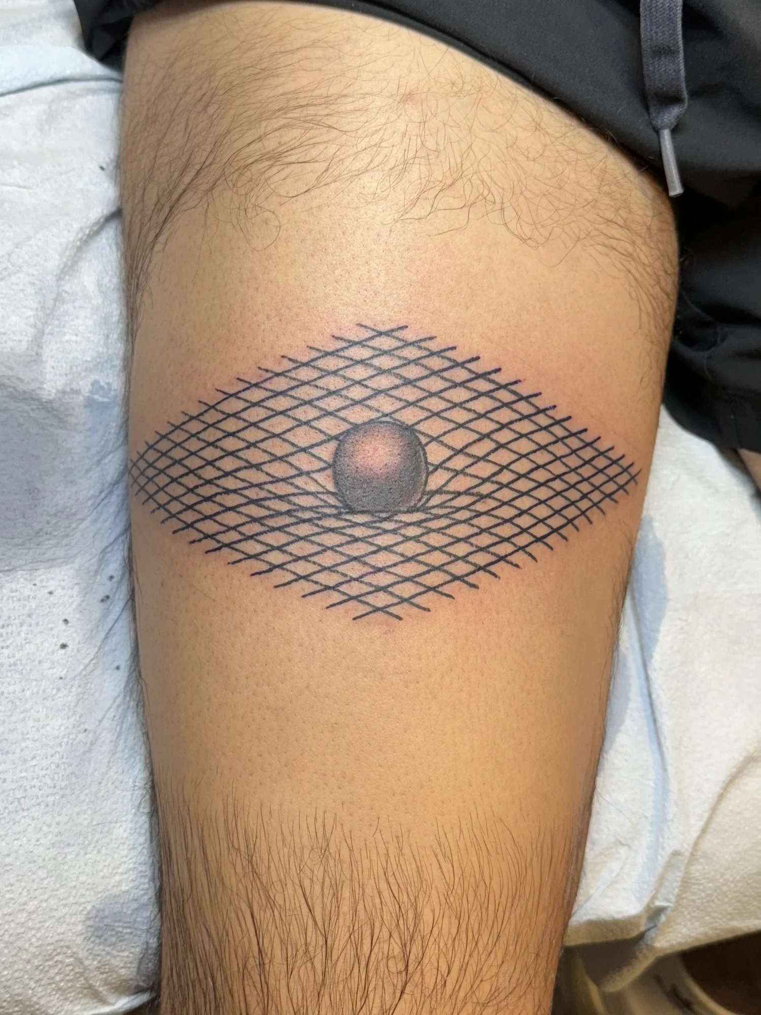 Fine line optical mesh and sphere tattoo on a thigh.jpg