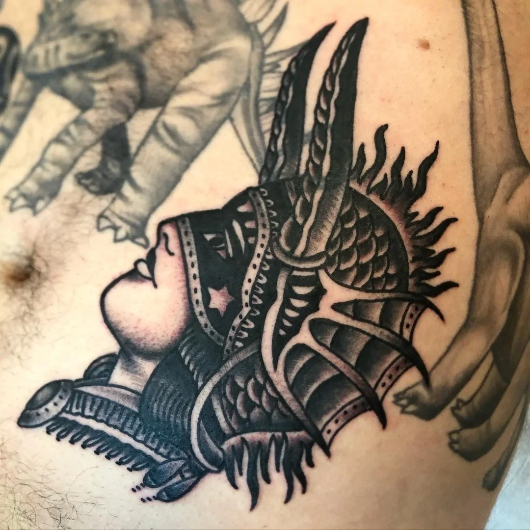 Black and grey warrior helmet tattoo with bold shading by Electric Lotus Tattoo in NYC