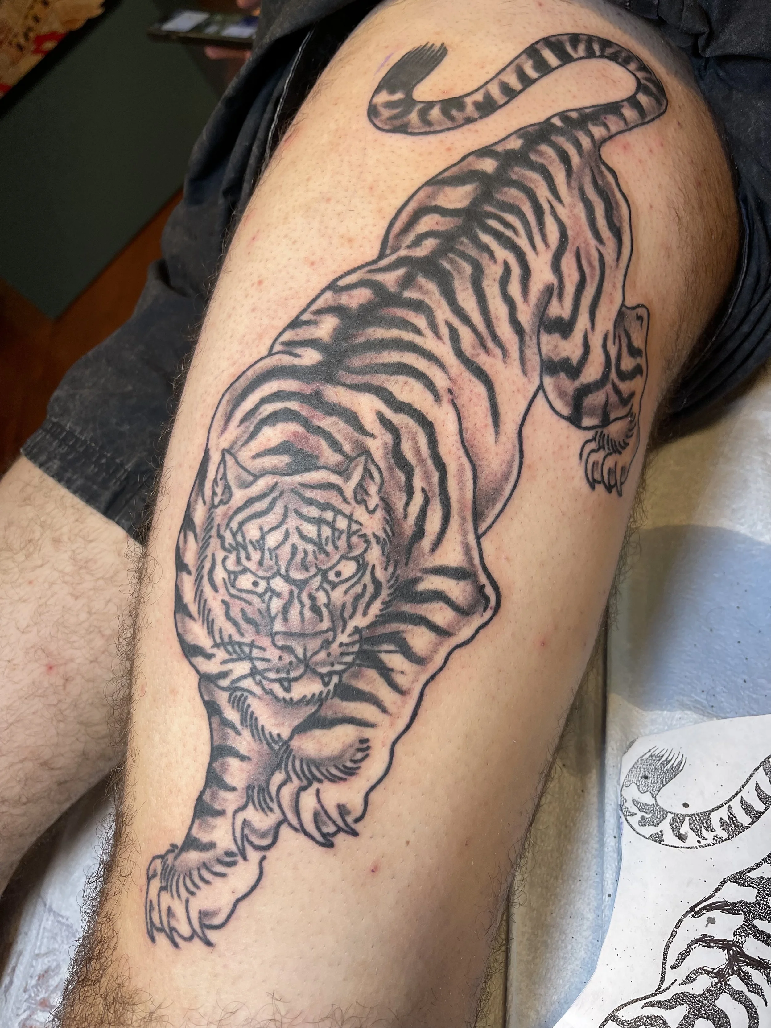 Black and grey tiger tattoo on the thigh by Electric Lotus Tattoo in NYC