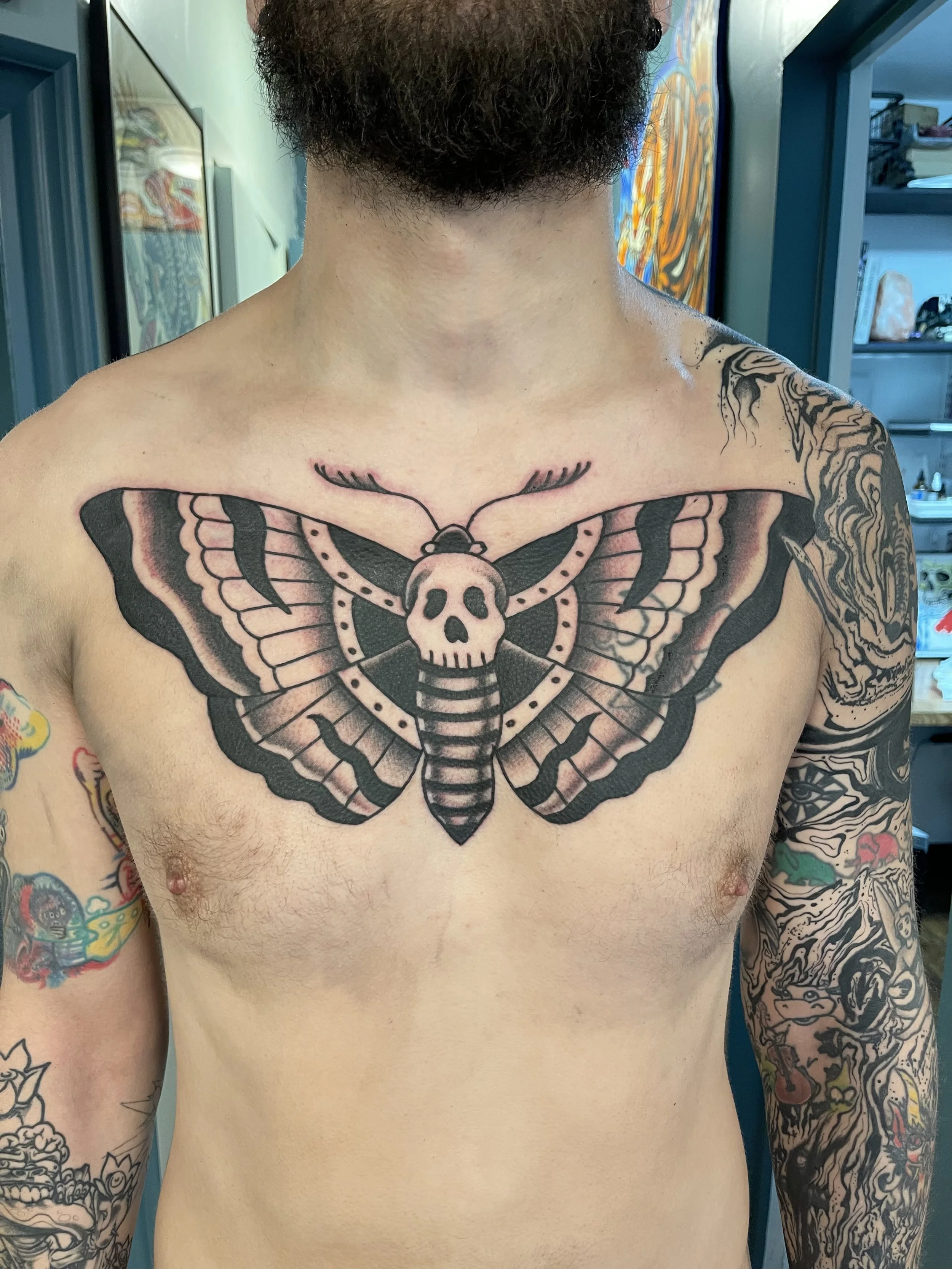 Black and grey death head moth chest tattoo by Electric Lotus Tattoo in NYC