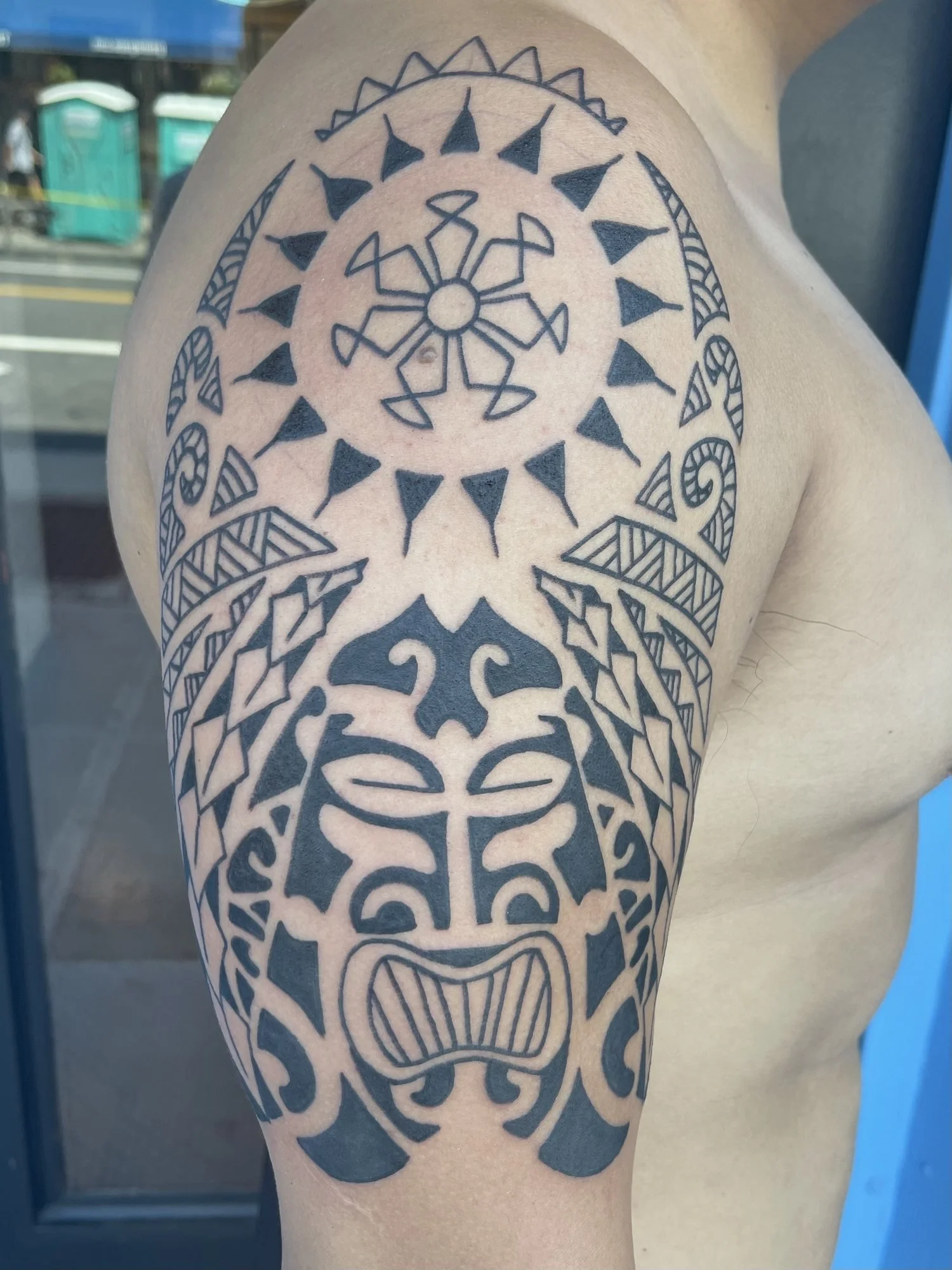 Polynesian style blackwork tattoo across a shoulder and chest.jpg