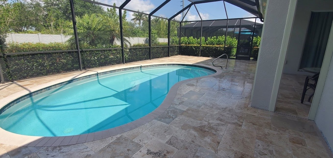 Freshly sealed travertine paver pool deck with restored color in Miami, FL