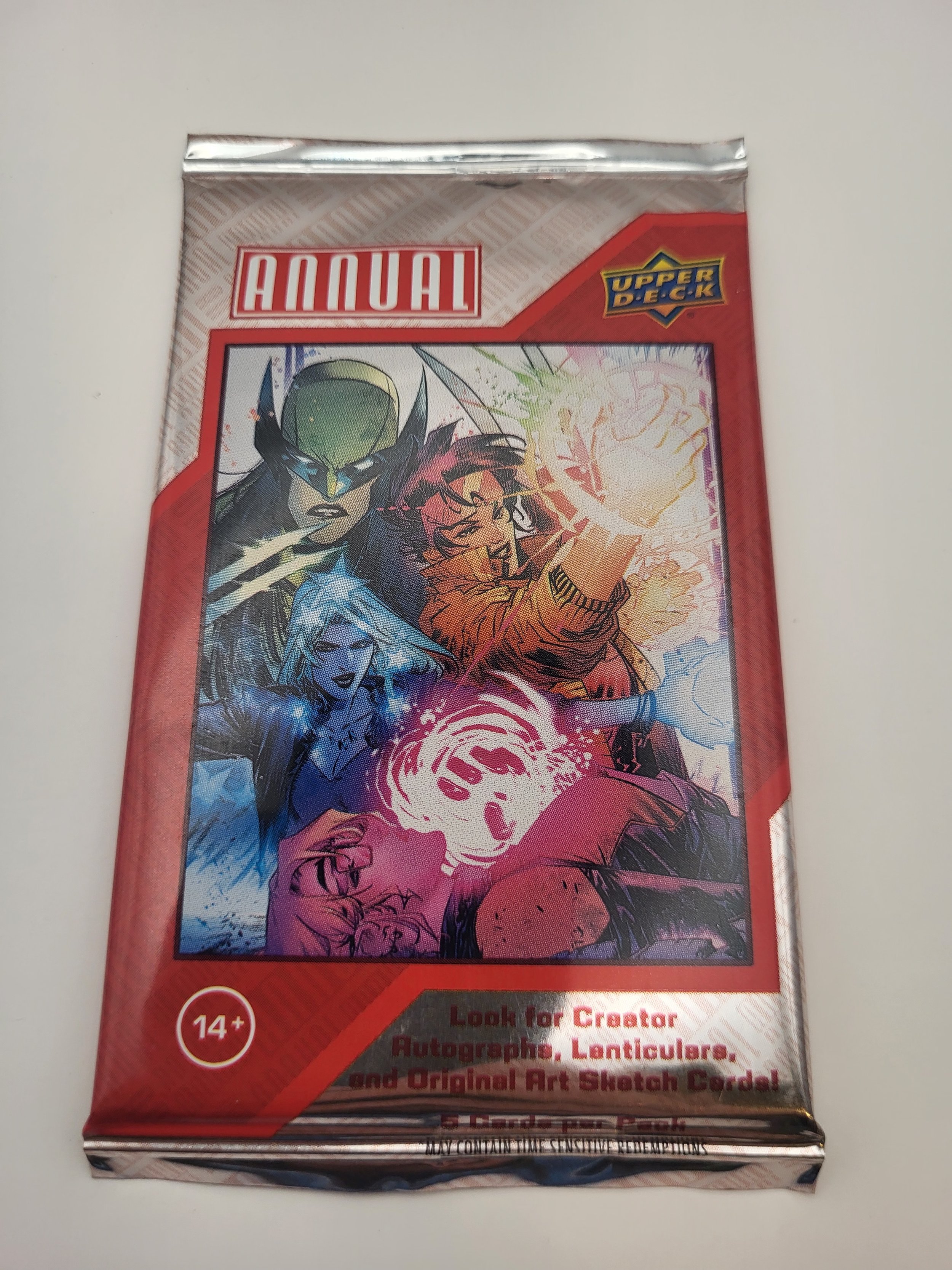 A sealed booster pack for the Upper Deck Marvel annual trading card set, featuring comic-style illustrations of Marvel characters like a green helmeted character, a woman with white hair, a man with a glowing green hand, and others, with a red and silver design.