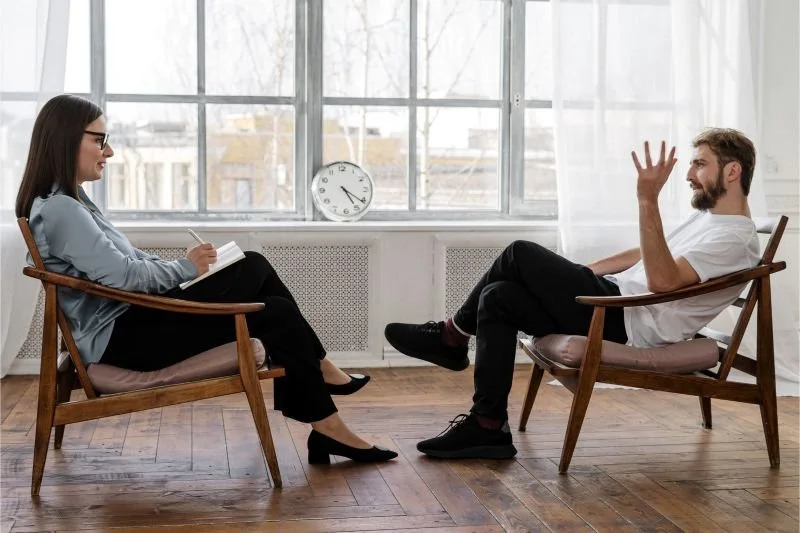 Mujer coach en una sala efectuando una sesión de coaching de vida con un paciente
