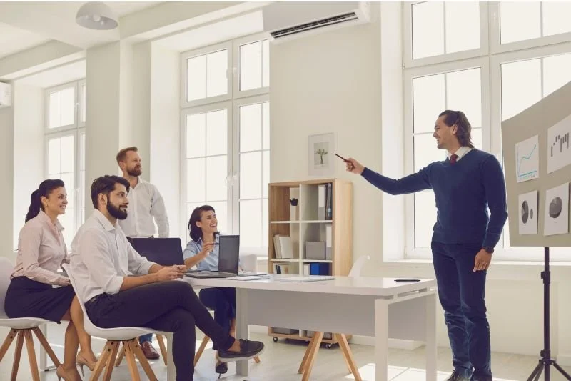 Coach de equipo en sesión con un grupo de trabajo en una empresa
