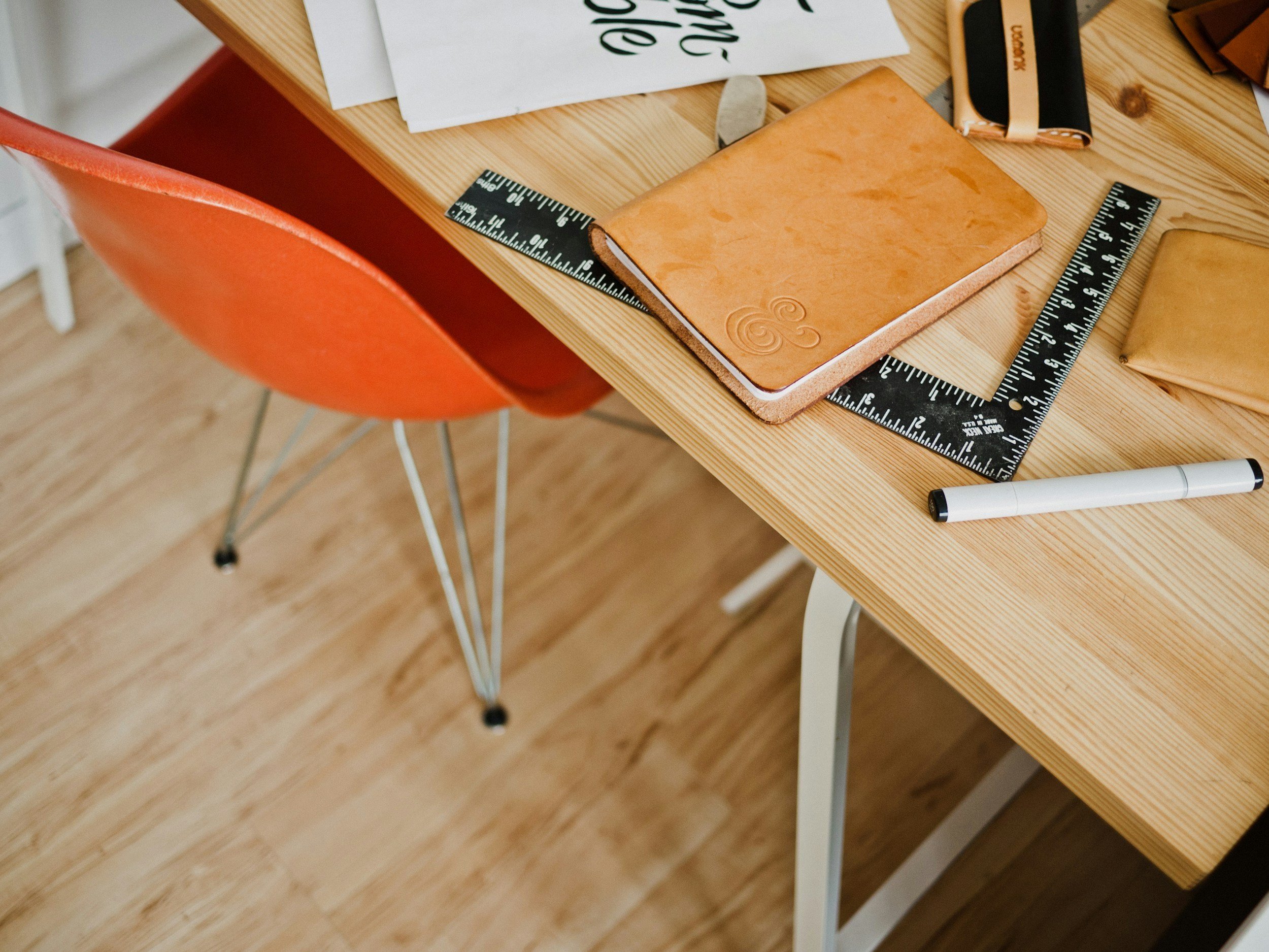 A lovely wooden desk and an orange chair.