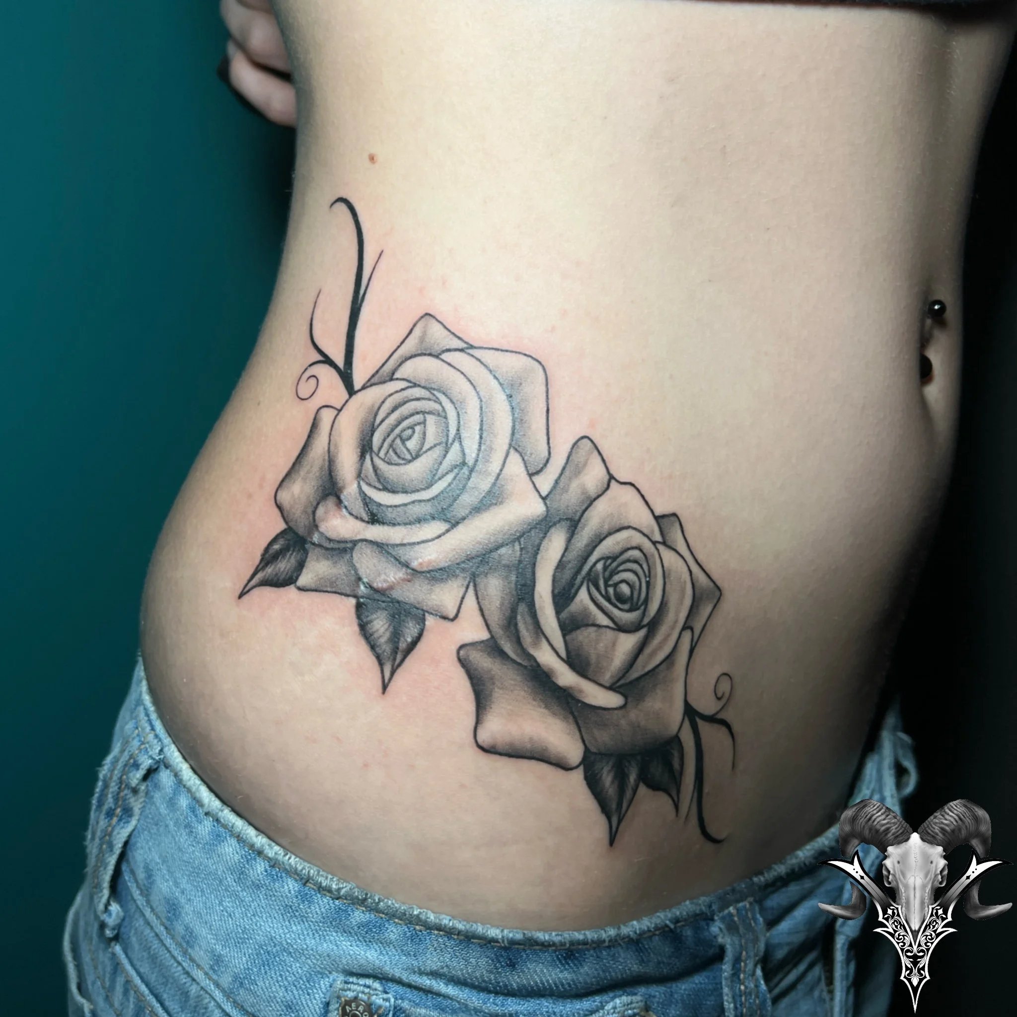Illustrative black and grey roses tattoo on the ribs by Mi Vida Tattoos