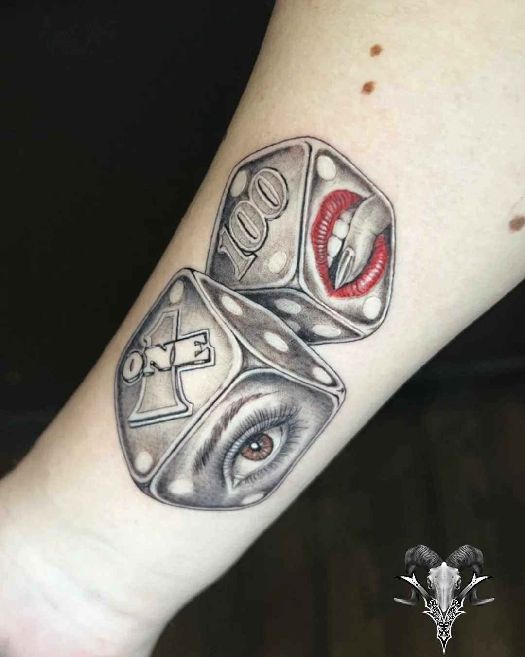 Black and grey dice tattoo with red accents by Mi Vida Tattoos