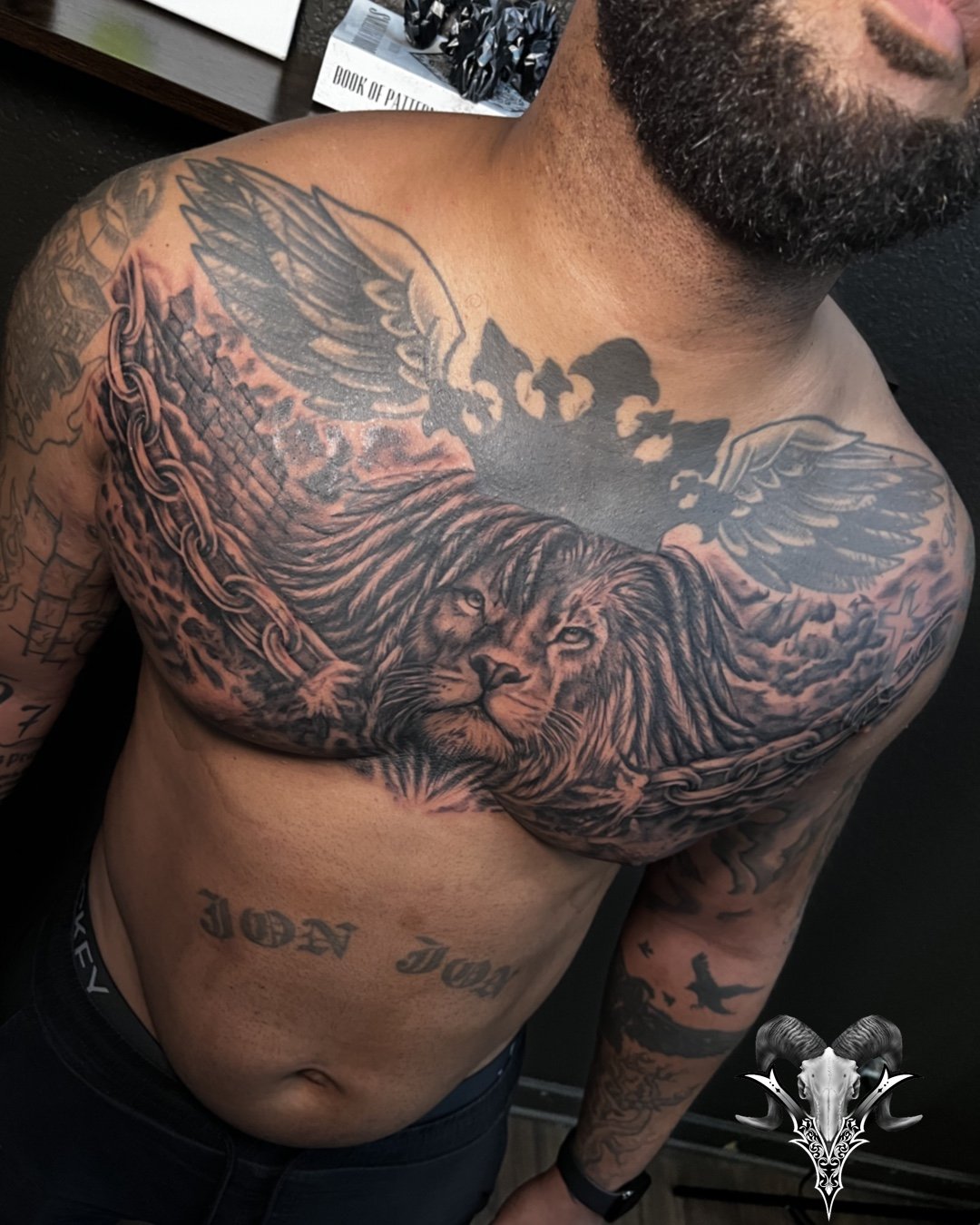 Black and grey lion chest tattoo by Jose Lopez at Mi Vida Tattoos