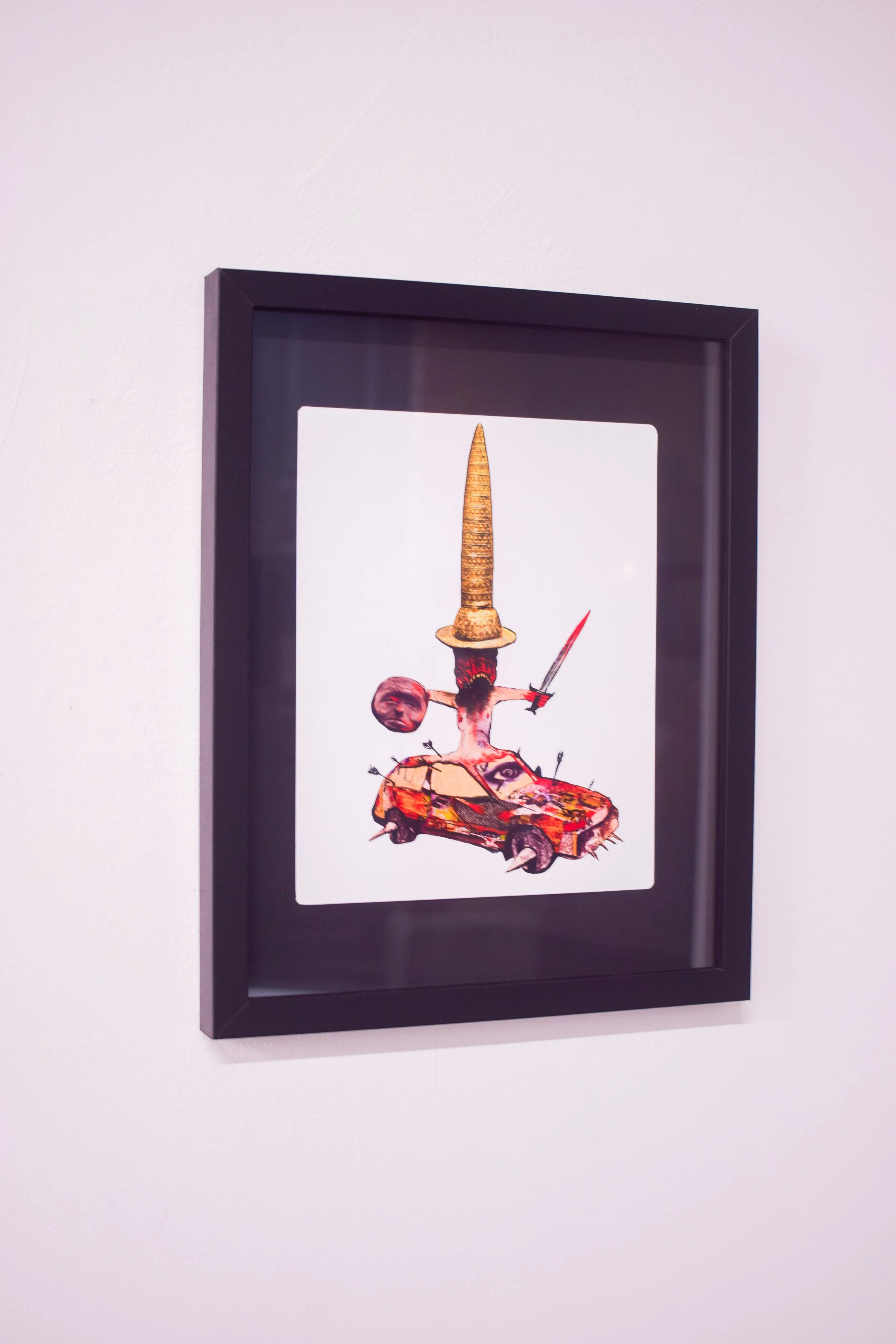 A framed digital artwork featuring a surreal collage with a carrot as a tall hat, a car with a face, a hanging head, a sword, and various abstract elements.