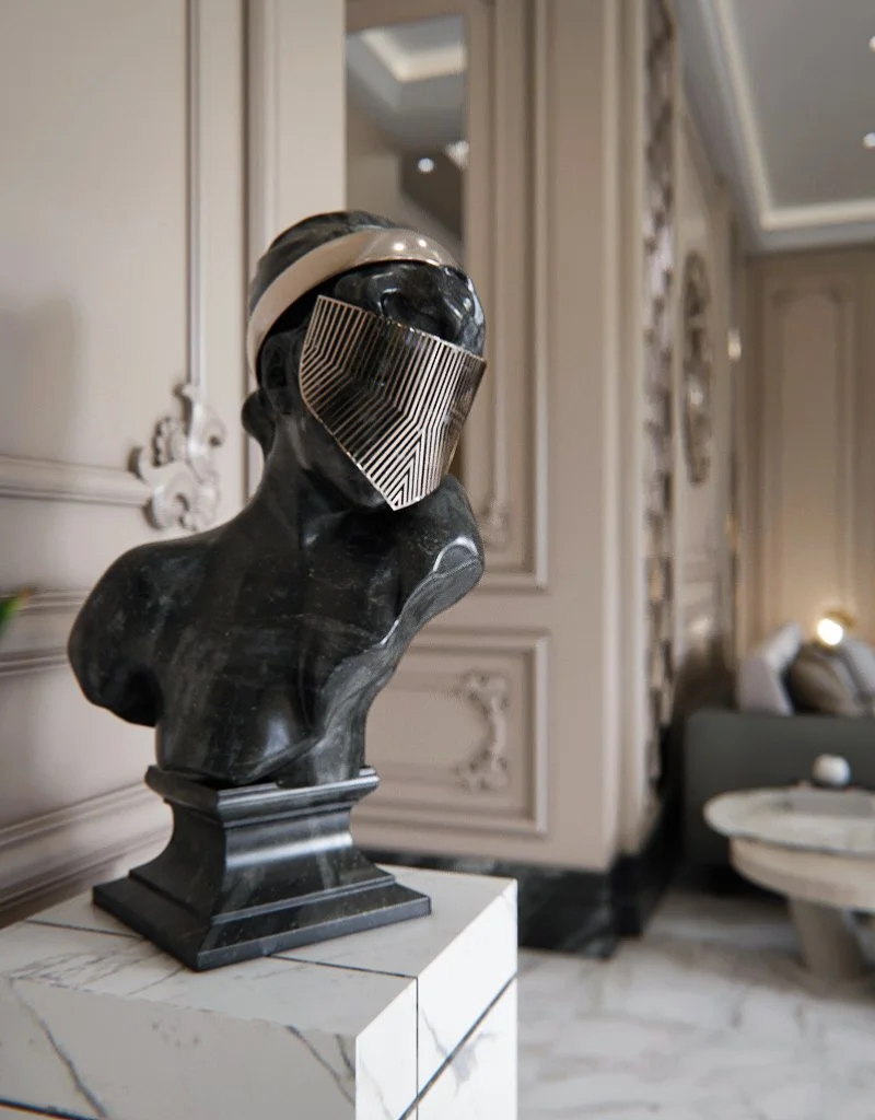 A black marble bust sculpture with a futuristic silver face mask and headband, displayed on a white marble pedestal in an elegant interior.