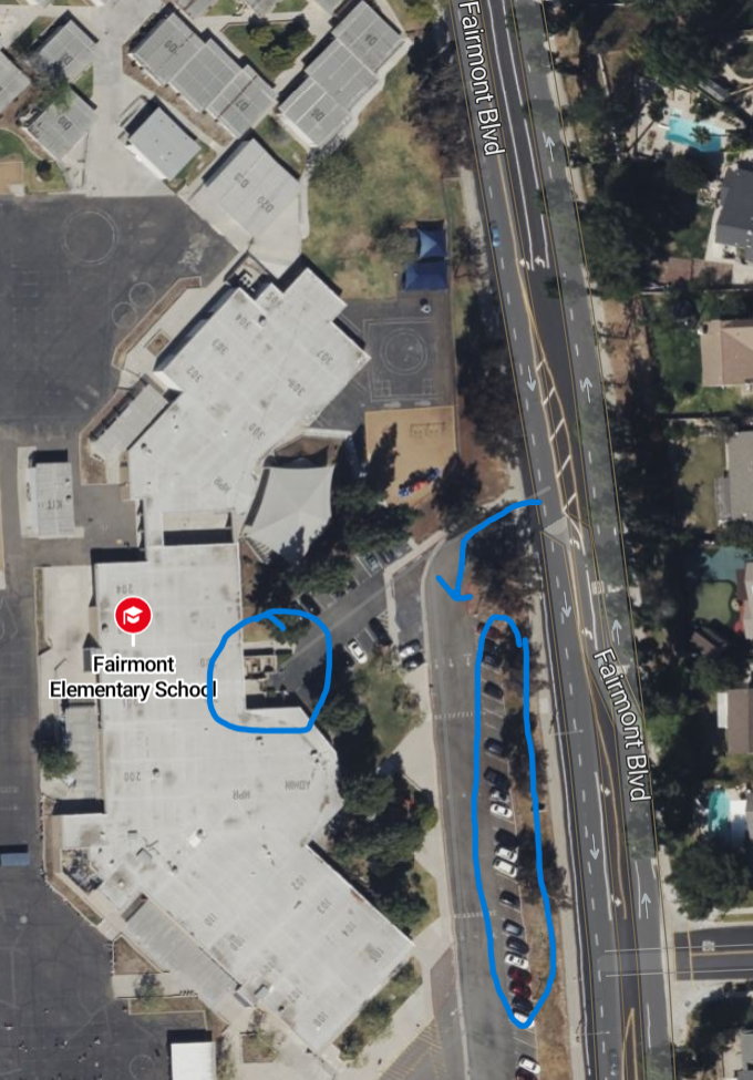 Aerial view of Fairmont Elementary School with parking area and surrounding residential neighborhood, showing a route marked with blue arrows.