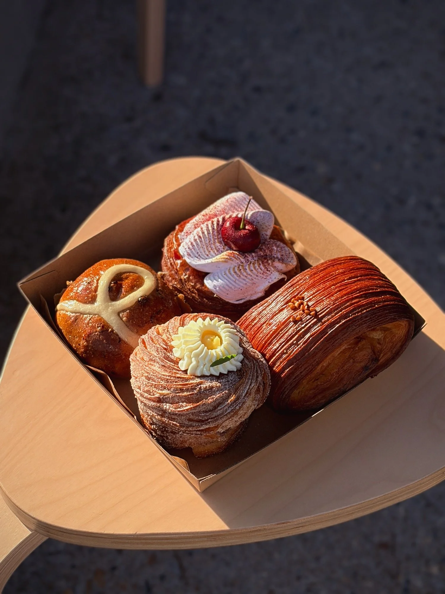 Cardboard tray with 4 beautiful pastries glistening in the morning sun