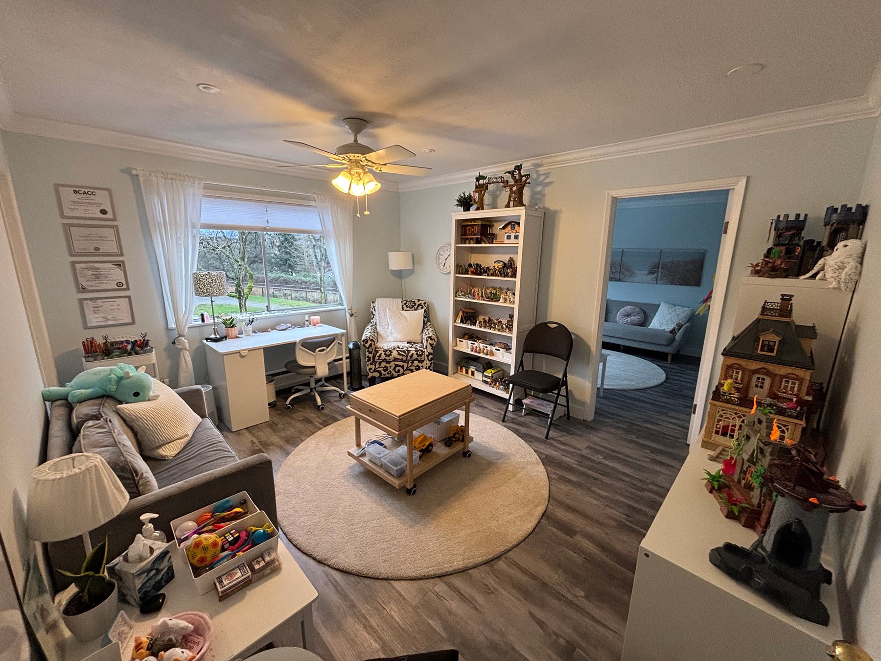Children's therapy office with a couch, sand tray and lots of toys.