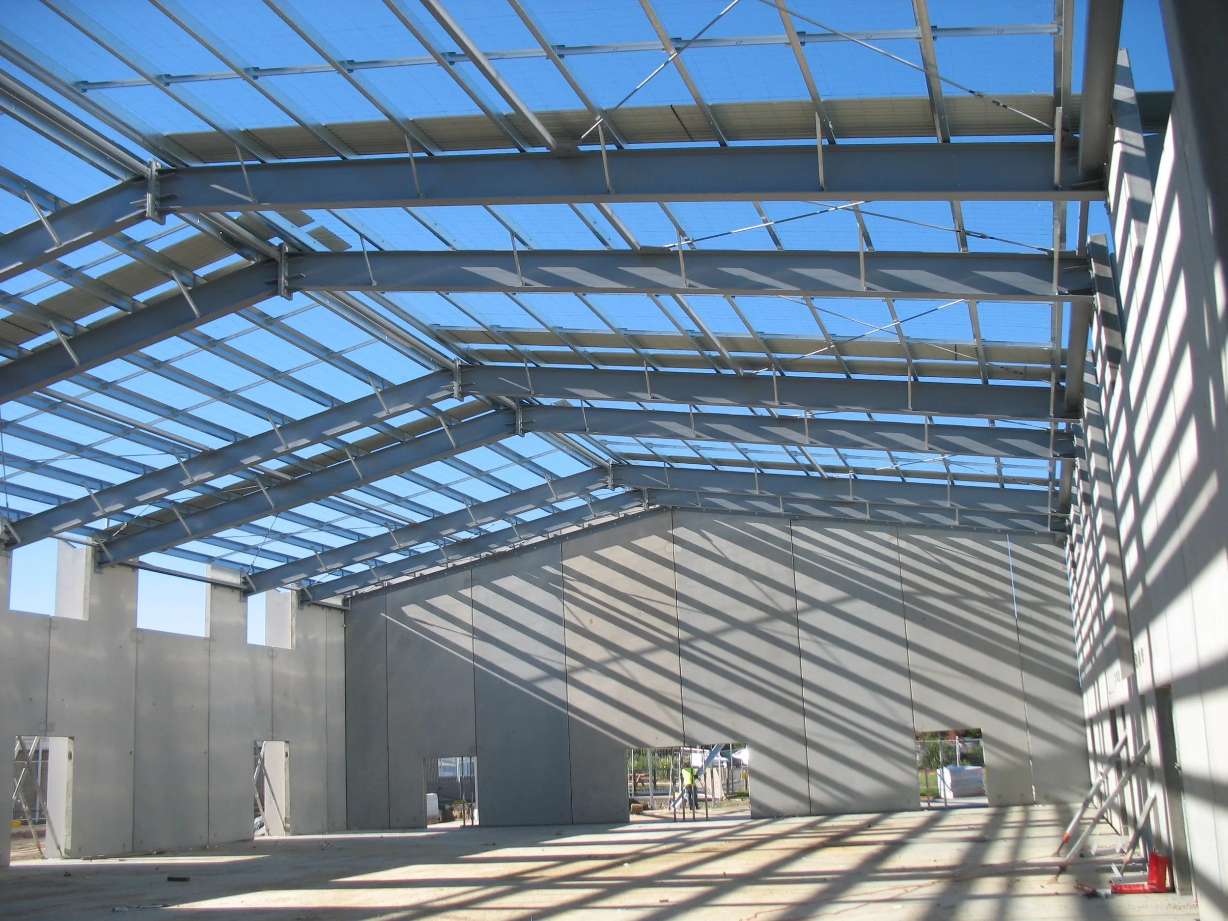 Industrial building under construction with steel frame and concrete walls